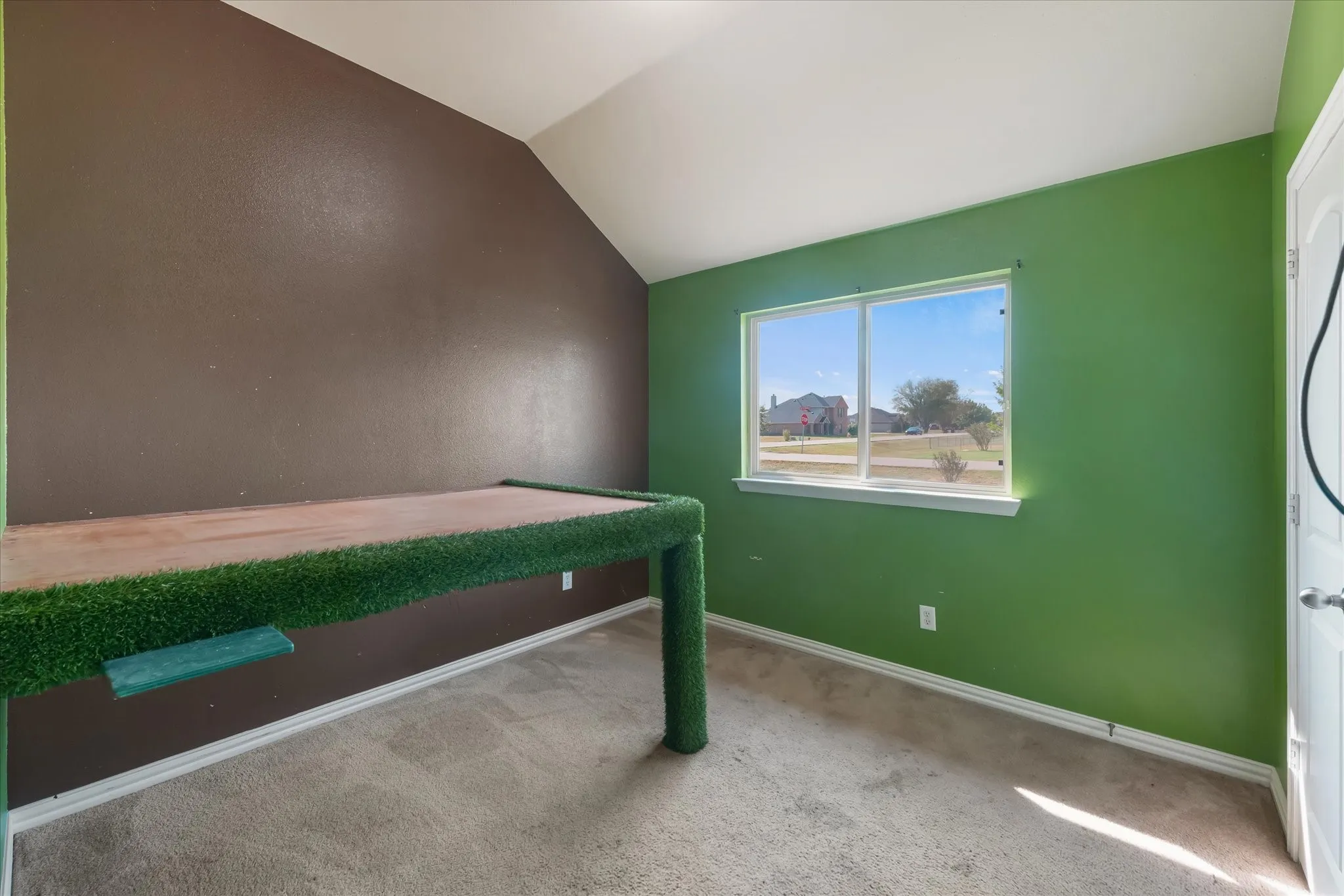 Vaulted ceiling, dual-pane window, carpet flooring, textured walls, and a white interior door
