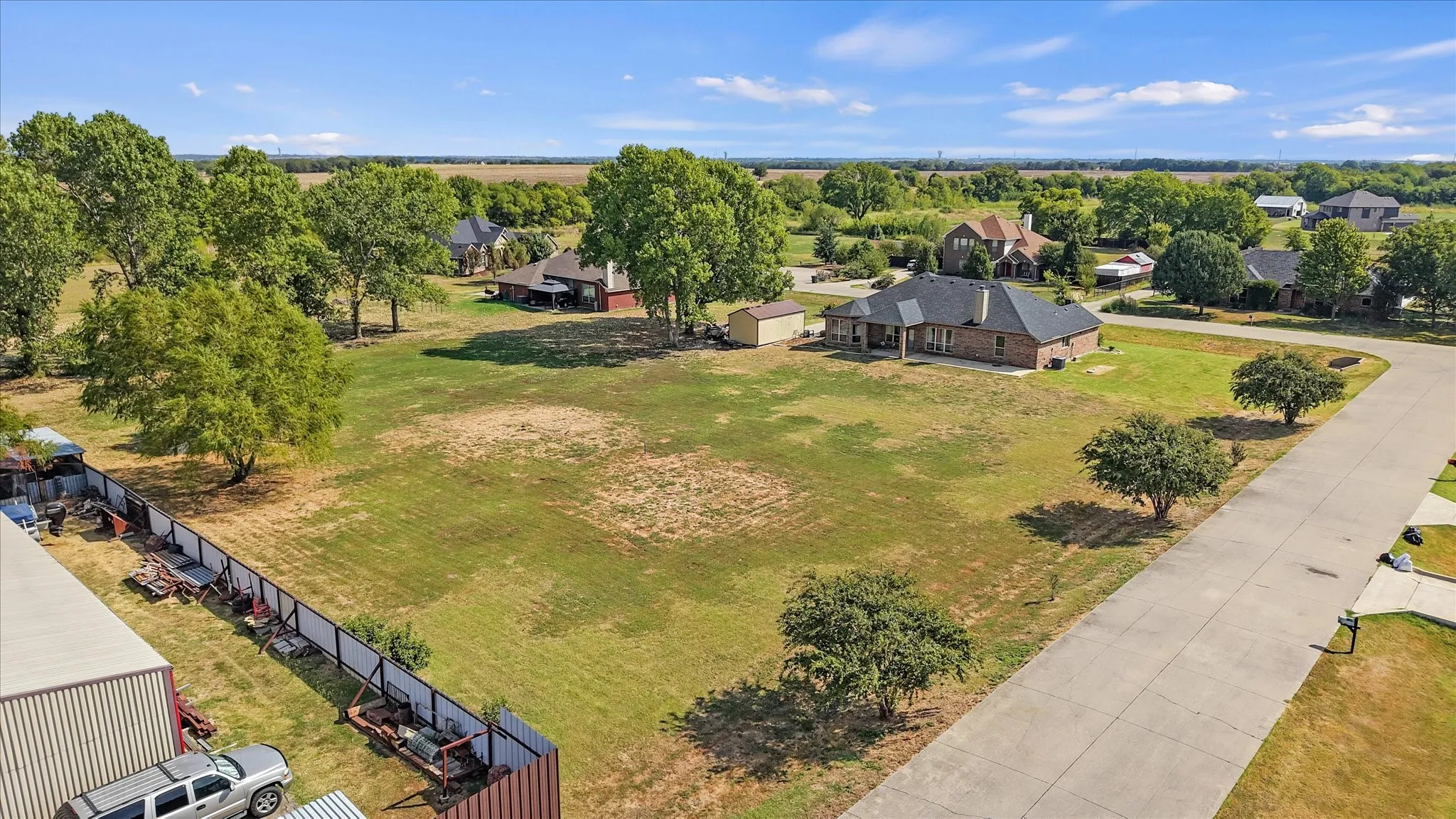 Brick exterior residence with an attached garage, a covered patio, and a separate storage shed