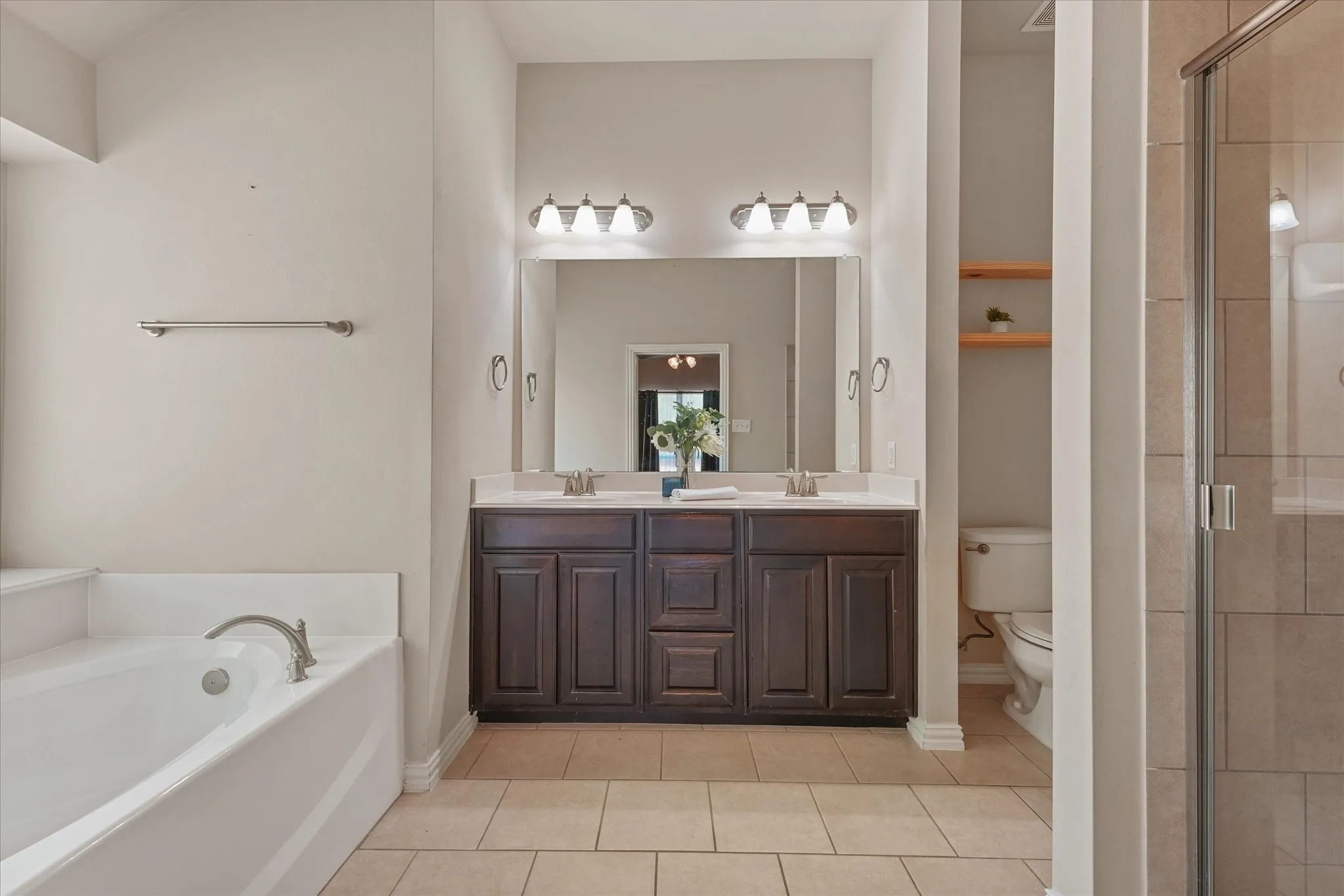 Double vanity with dark wood-finish cabinetry, dual undermount sinks, and a single-handle faucet
