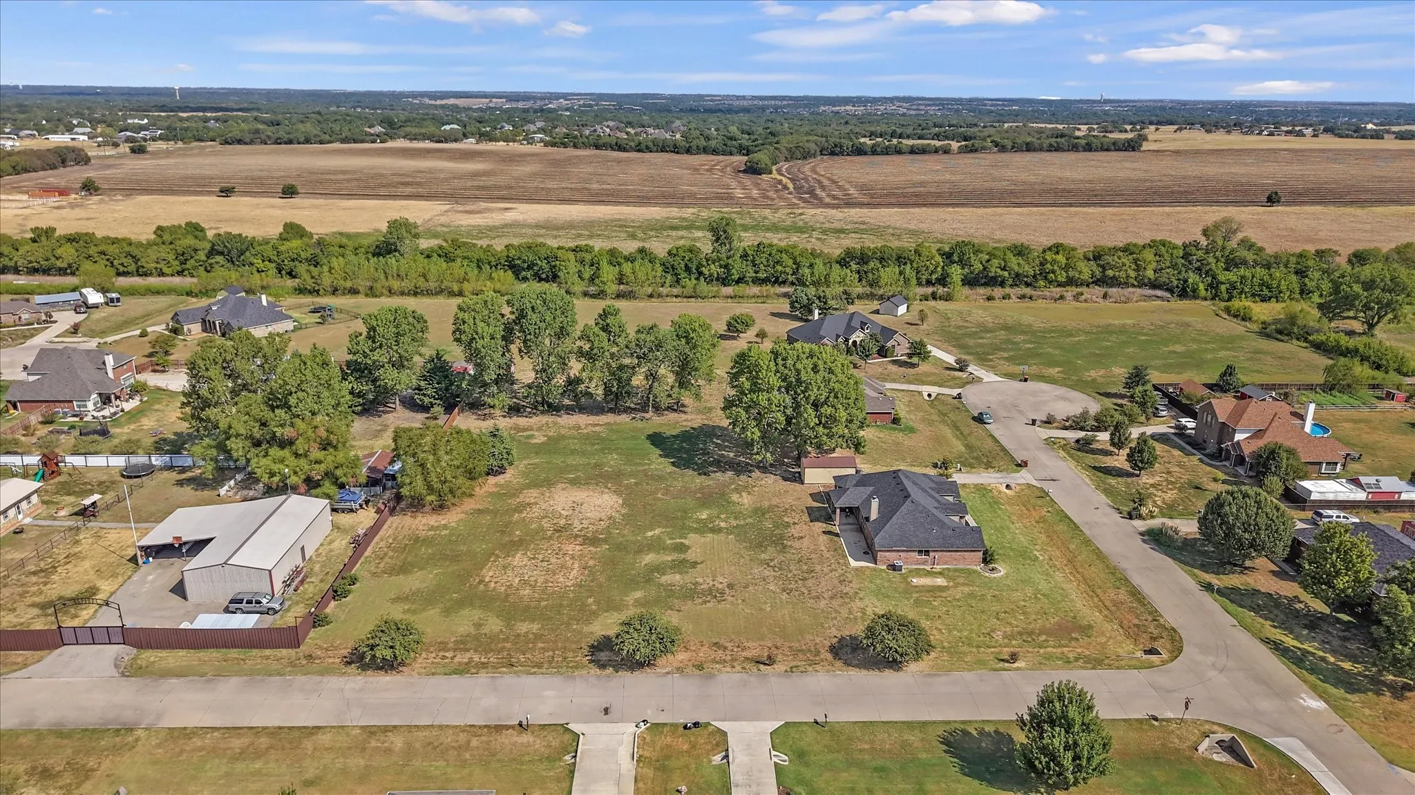 Expansive land parcel featuring open fields and distant tree lines