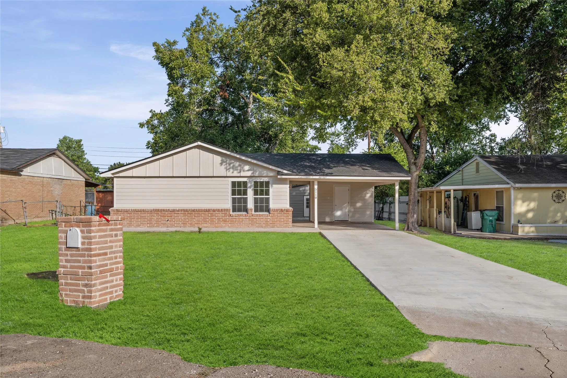 Single-story residence featuring a partial brick facade, light-colored siding, and a covered carport