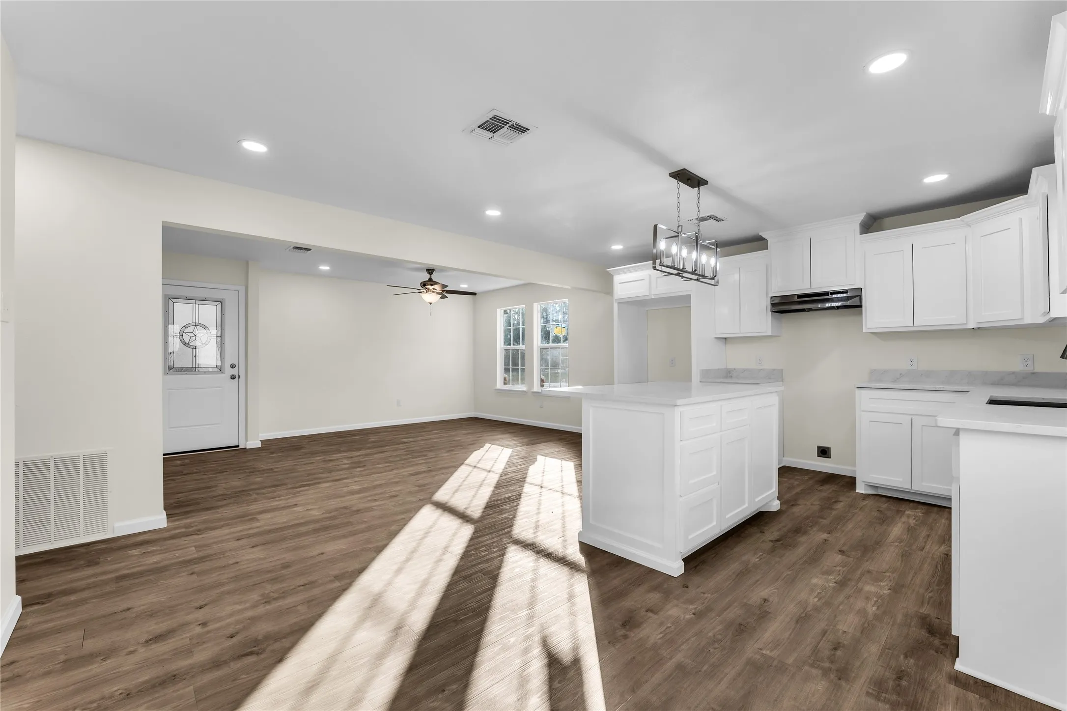 Open concept living area with wood-finish flooring, recessed lighting, and a ceiling fan
