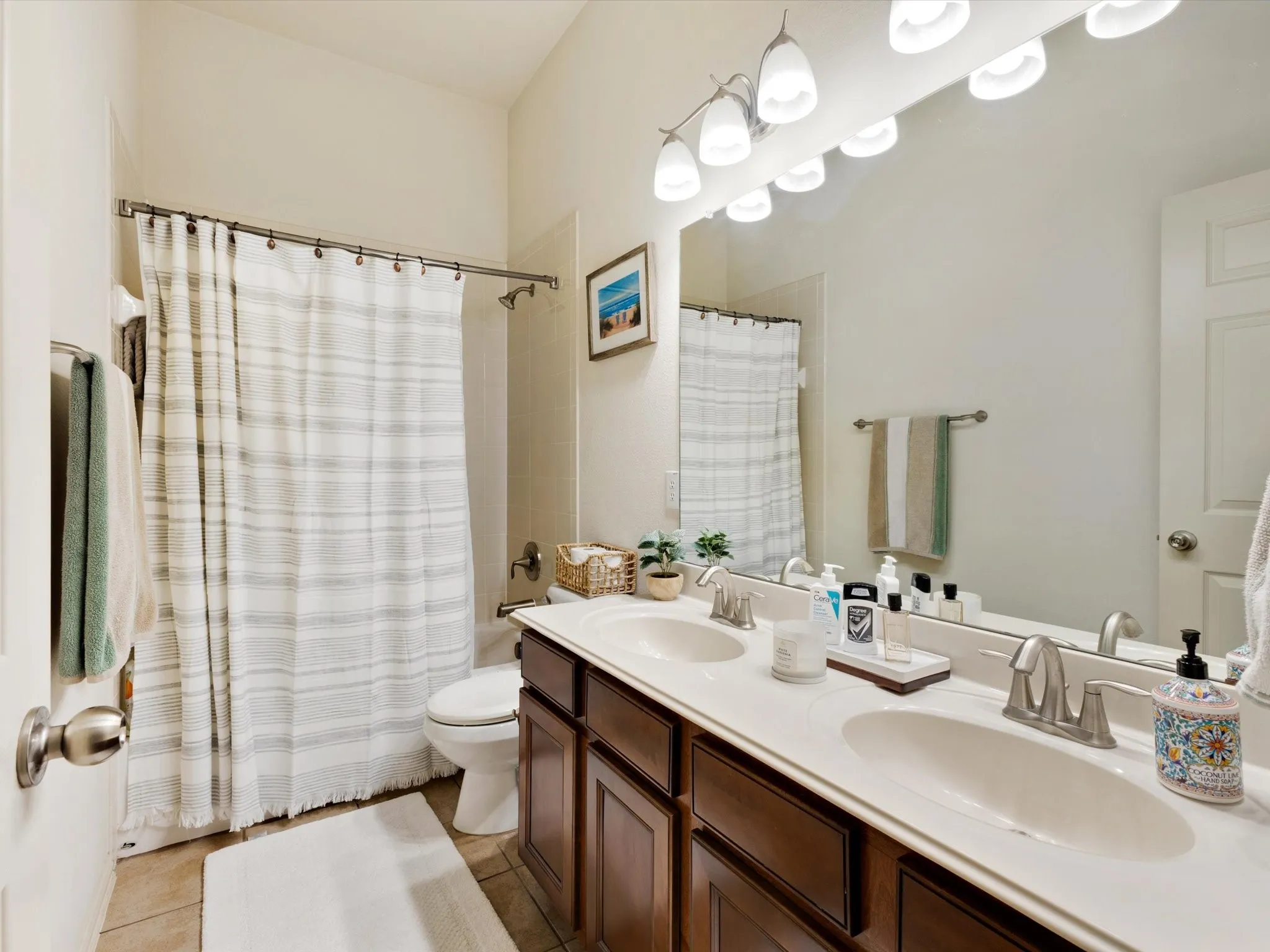 Dual vanity with integrated sinks, brushed nickel fixtures, and dark wood-finish cabinetry