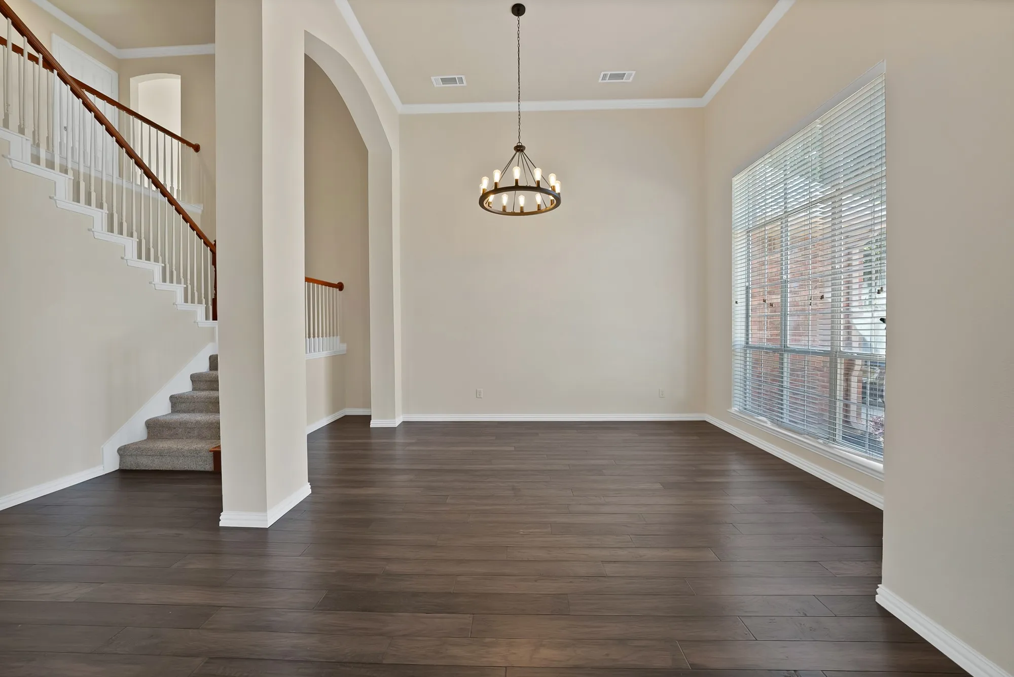 High ceilings with crown molding, wood-finish flooring, and a large window with blinds