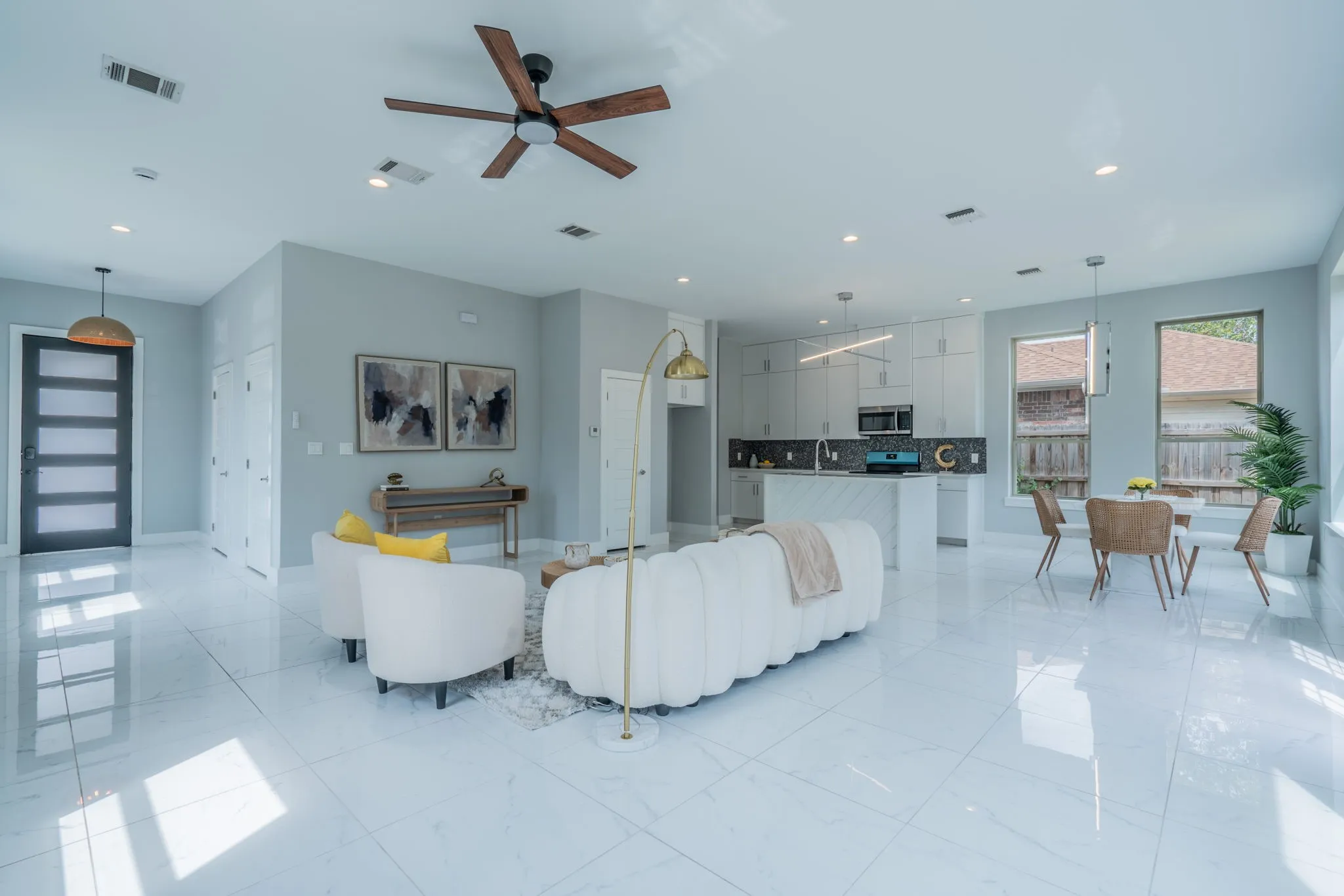 Open-concept living space featuring high ceilings, recessed lighting, and large format white tile flooring