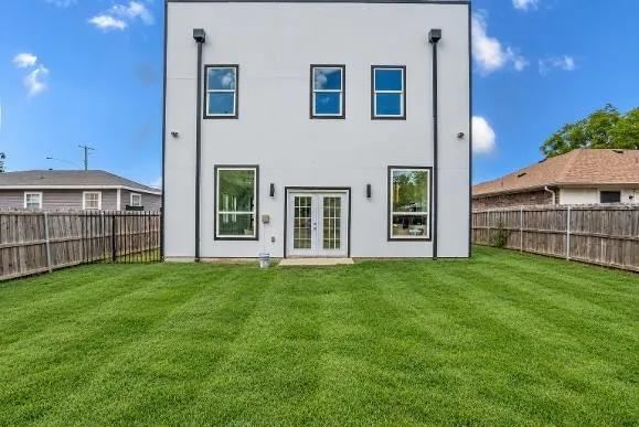 Expansive green lawn with a privacy fence