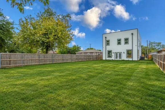 Expansive grass lawn with a full privacy fence