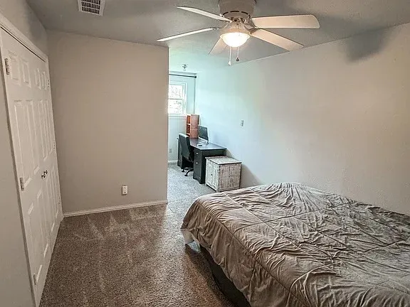 Neutral paint scheme, textured carpeting, contemporary ceiling fan, and a window for natural light