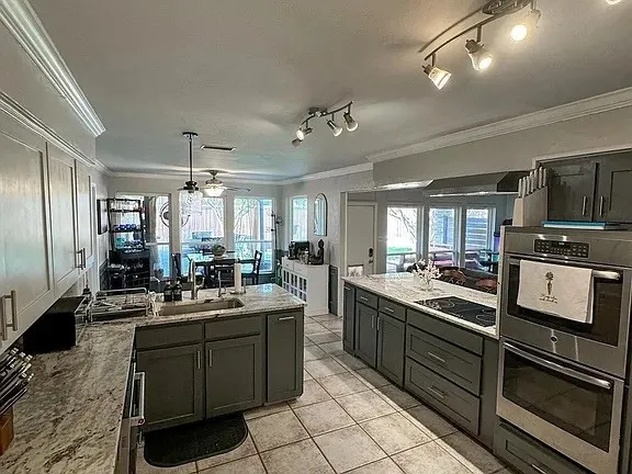 Kitchen featuring gray cabinetry, light-toned countertops, a built-in stainless steel double oven, a smooth cooktop, and tile flooring