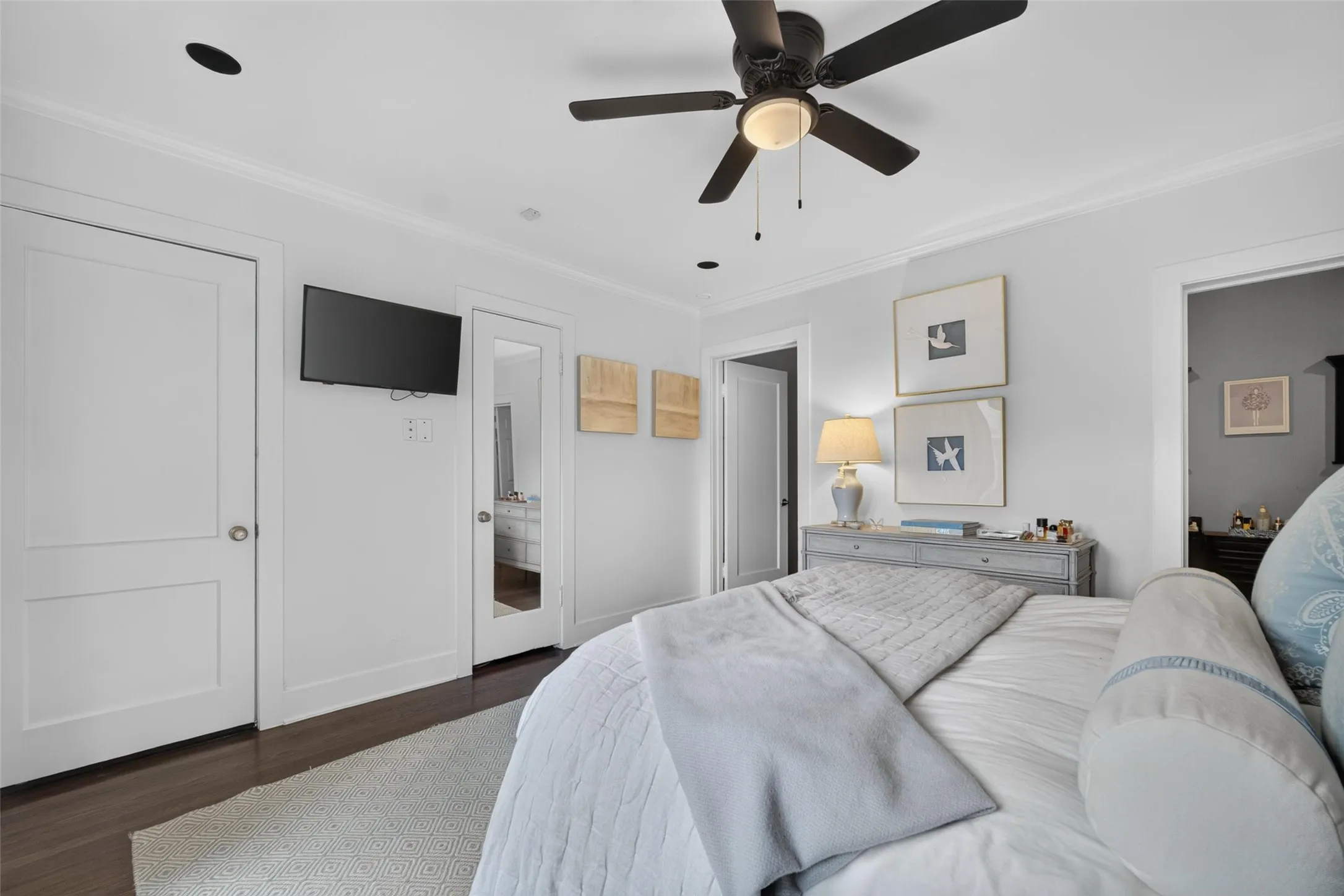 Recessed ceiling lighting, ceiling fan with light fixture, wood-finish flooring, crown molding, and panel doors