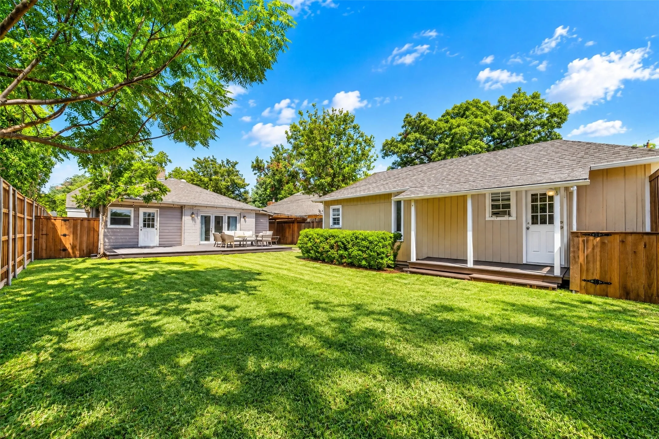 Expansive grassy lawn with a wood fence perimeter