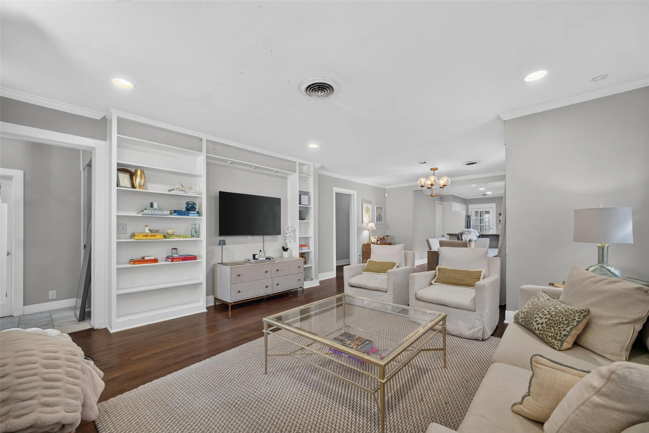 Hardwood flooring, recessed lighting, crown molding, built-in shelving, and an open-concept layout
