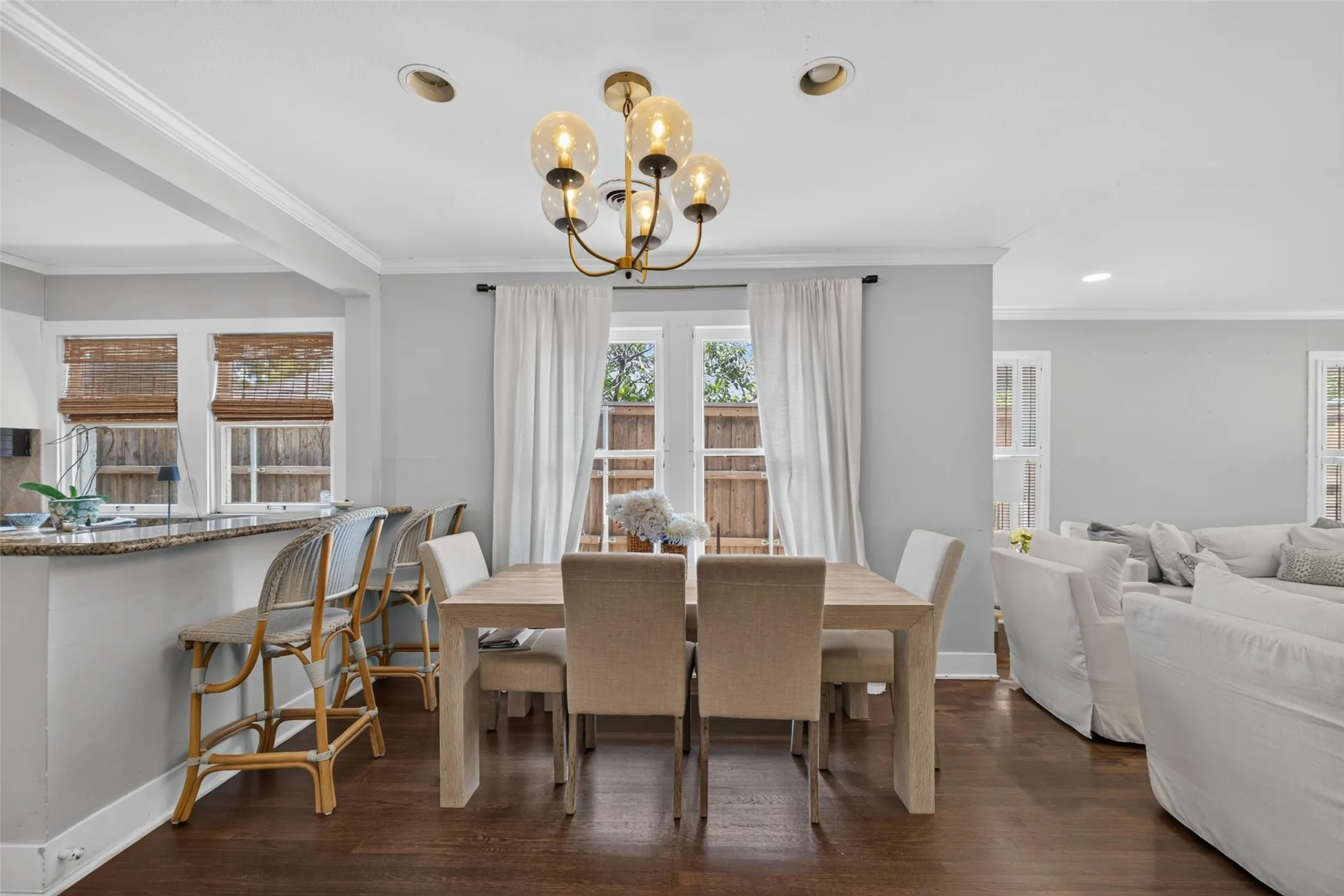 Recessed lighting, wood-finish flooring, gold-finish chandelier, crown molding, and a granite-finish breakfast bar