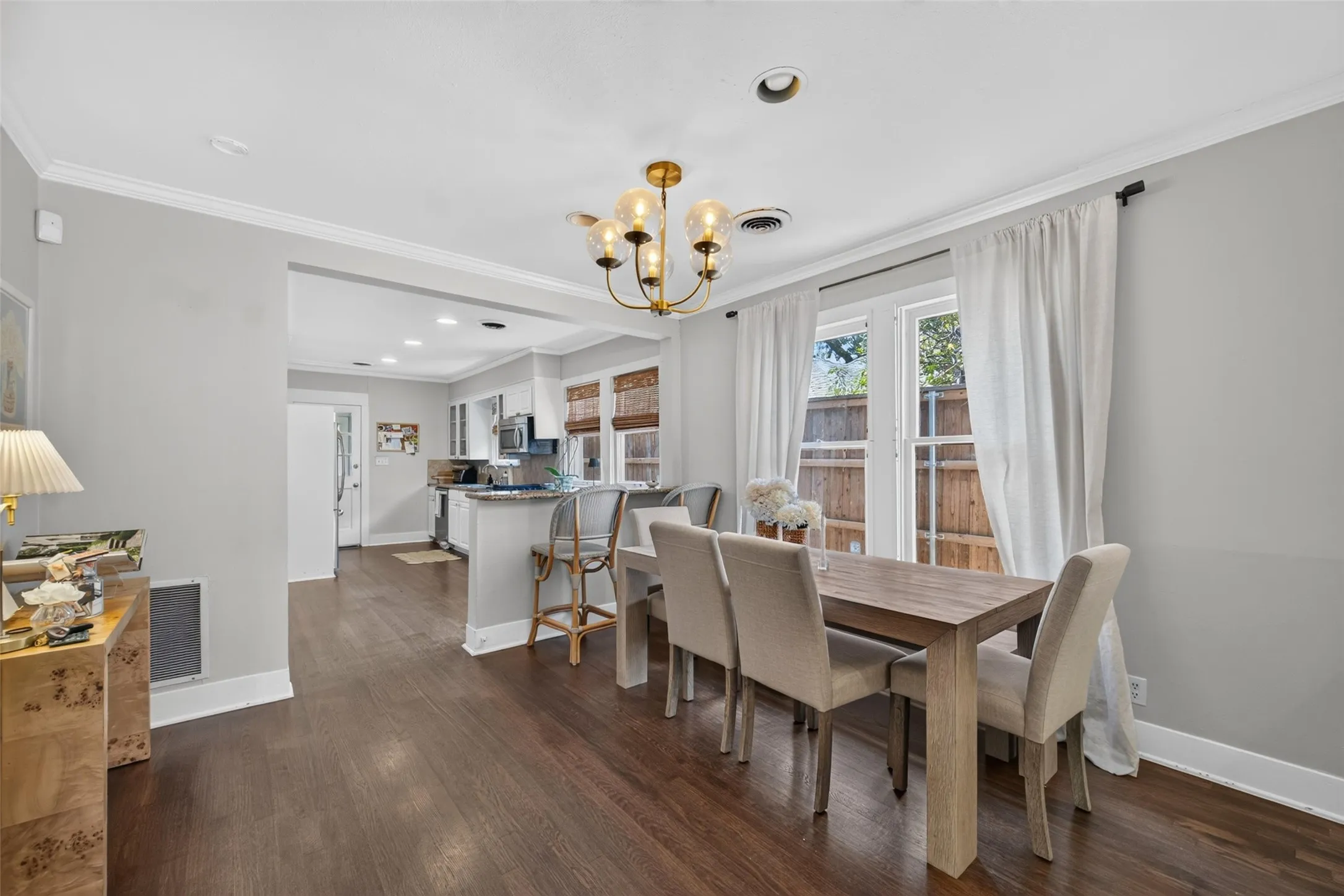 Wood-finish flooring throughout, recessed lighting, and a multi-light chandelier