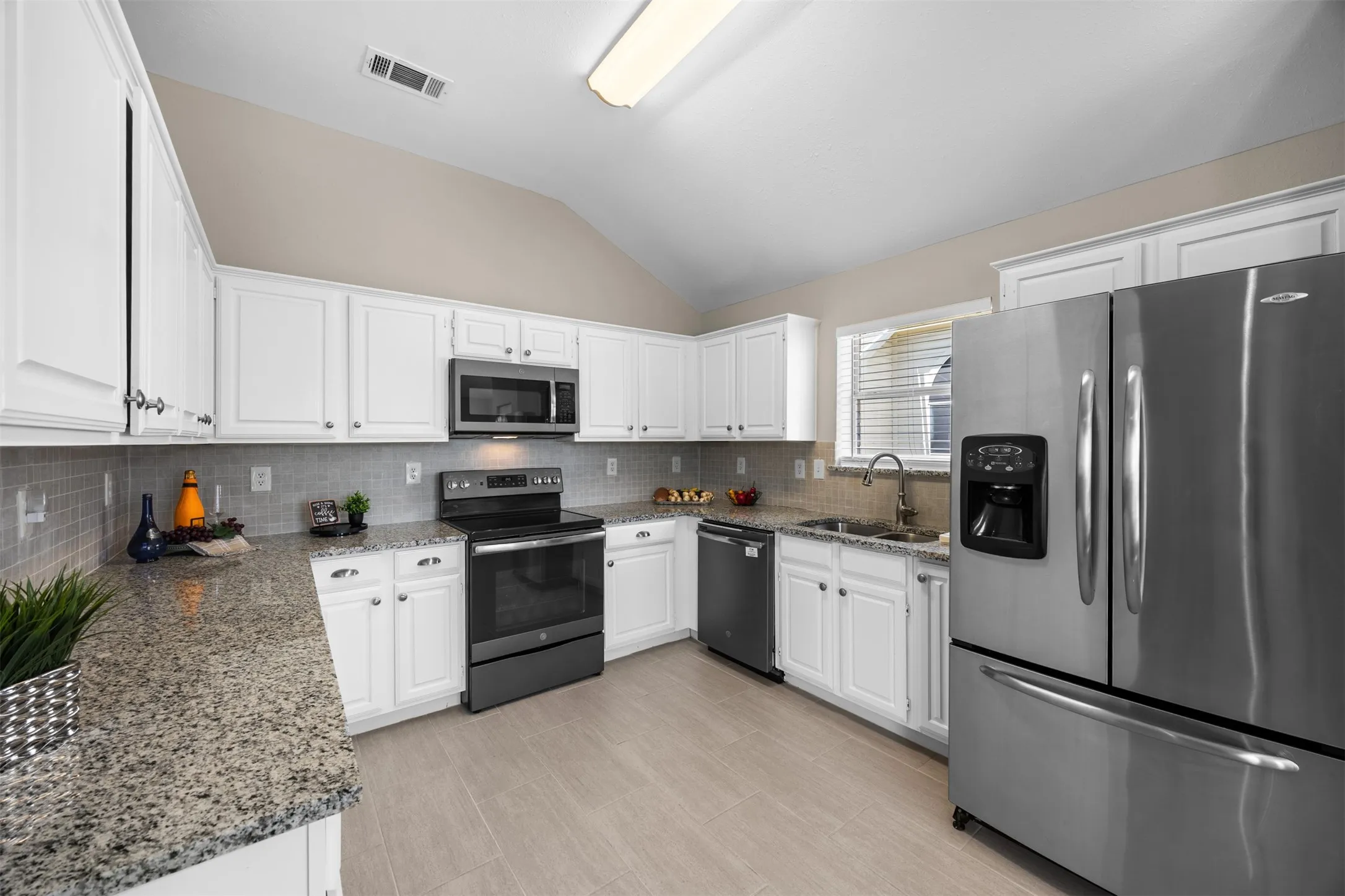 Updated kitchen with granite countertops and modern conveniences