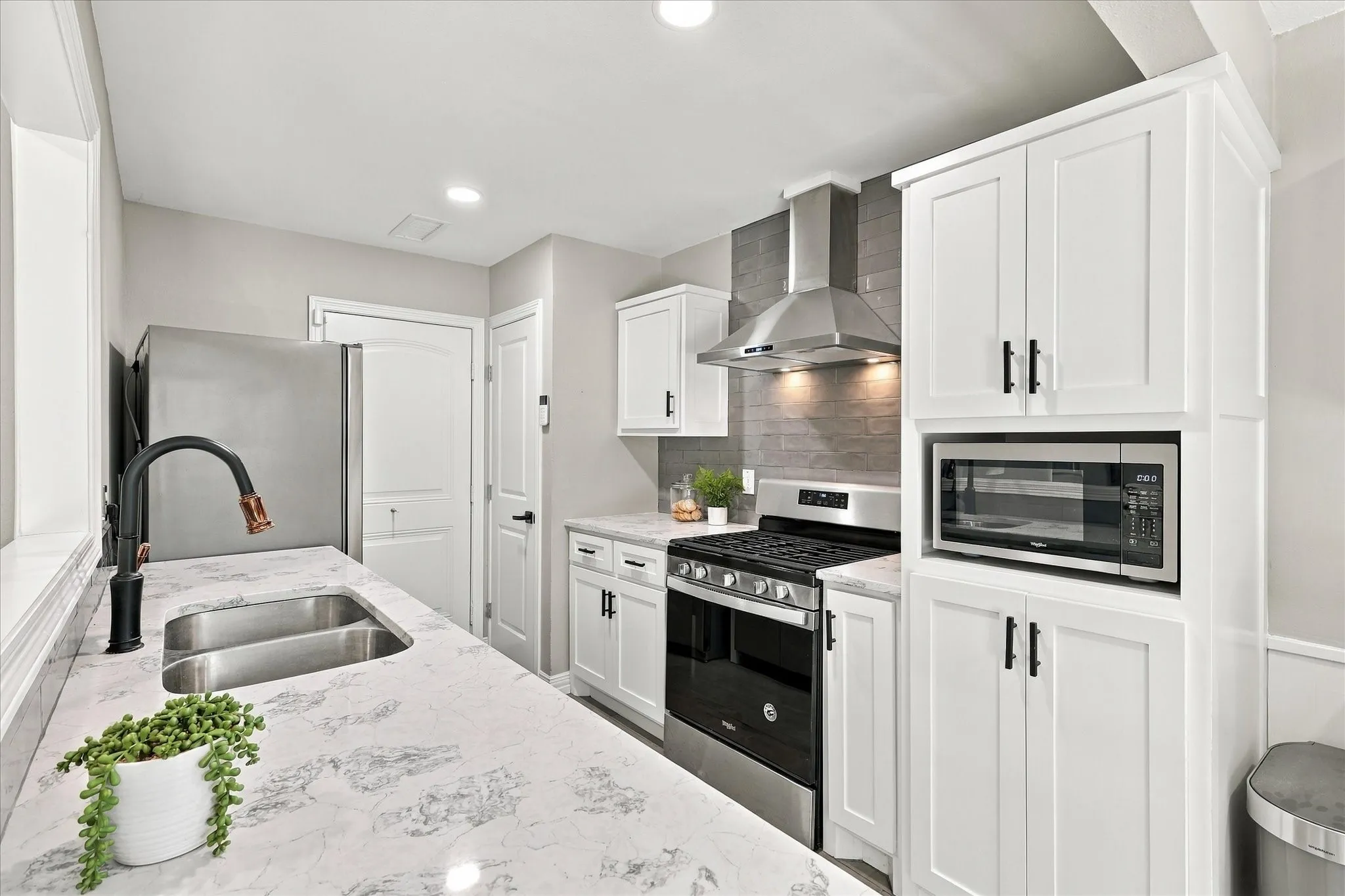 Gorgeous updated kitchen with gas stove, stainless appliances, french door fridge, wine fridge, fully updated cabinetry, and quartz counters