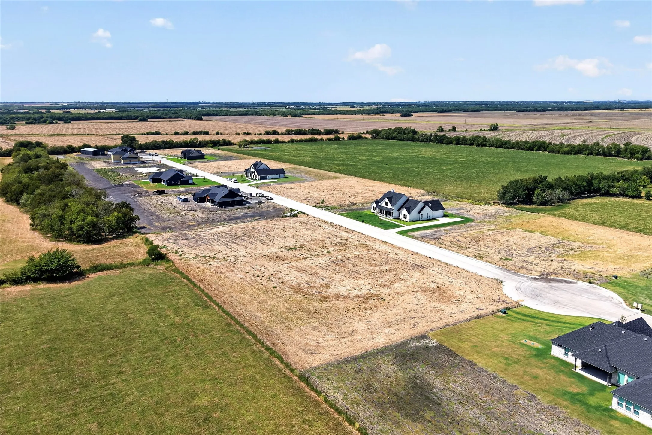 Expansive land parcels with residential development potential, featuring a paved roadway and a cul-de-sac