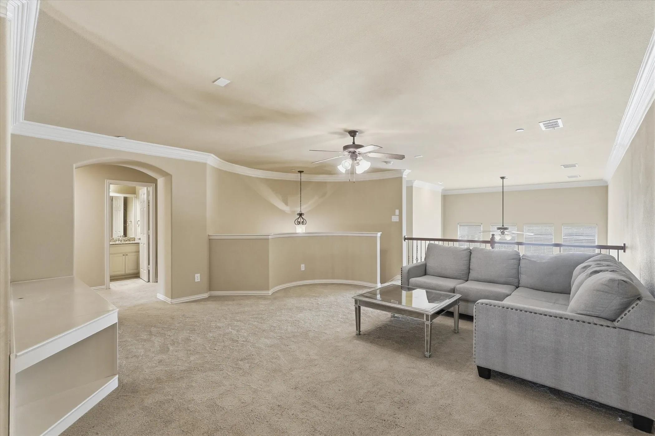  Upstairs Living room with ceiling fan, ornamental molding, light colored carpet, and arched walkways