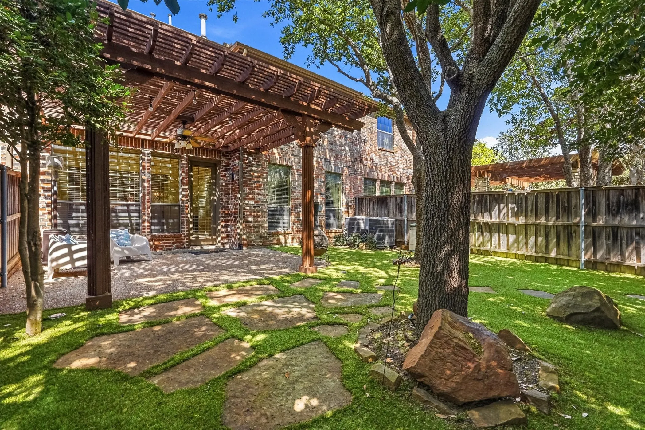 Fenced backyard featuring a patio, ceiling fan, and a pergola
