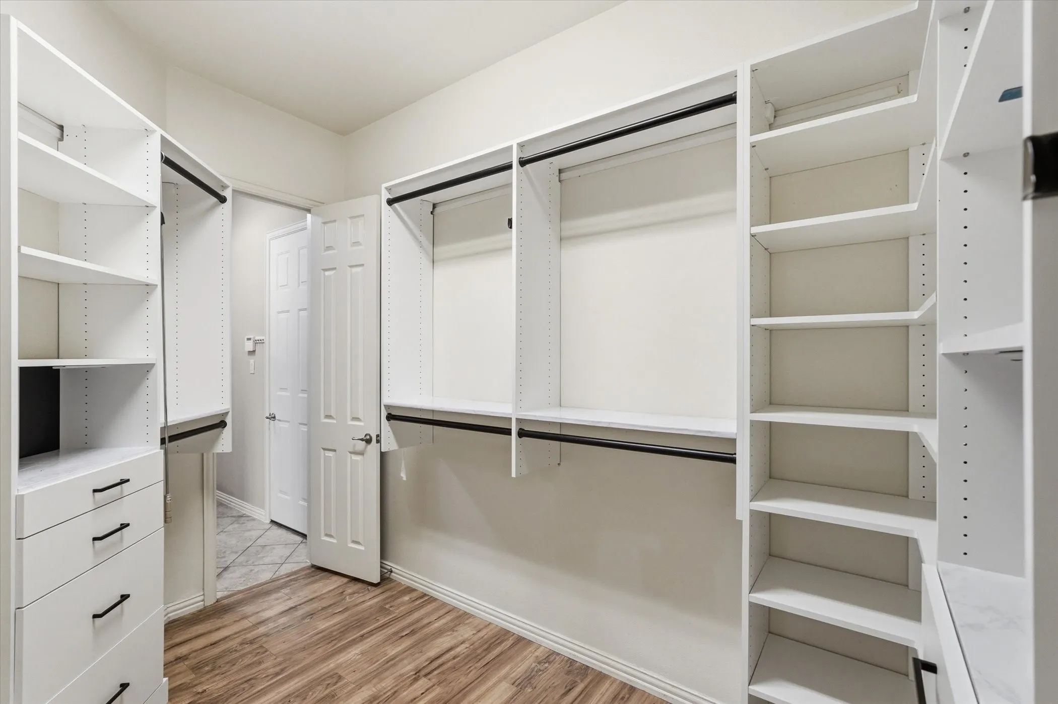 Walk in closet with light wood-style flooring