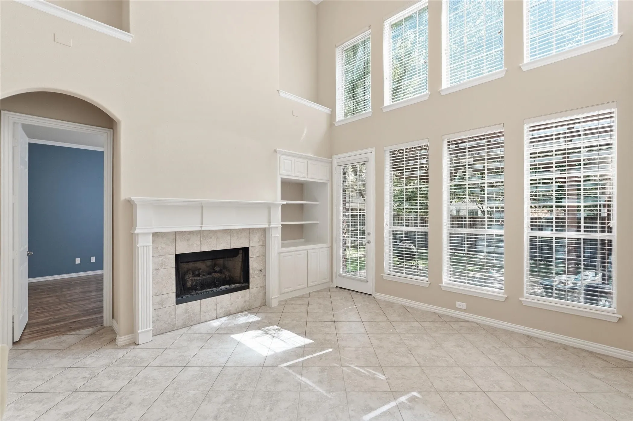 Unfurnished living room featuring plenty of natural light, a high ceiling, a fireplace, and built in features