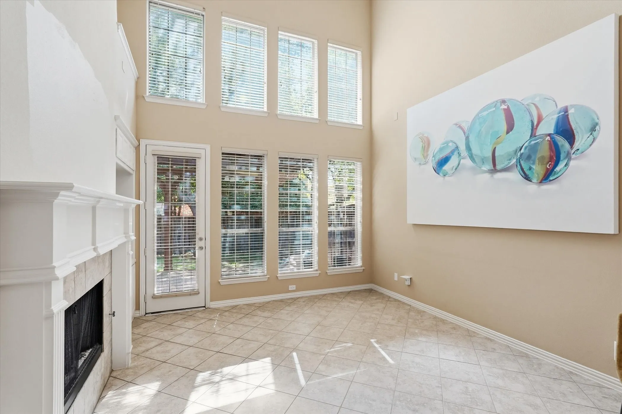 Unfurnished living room with plenty of natural light, a high ceiling, and a high end fireplace