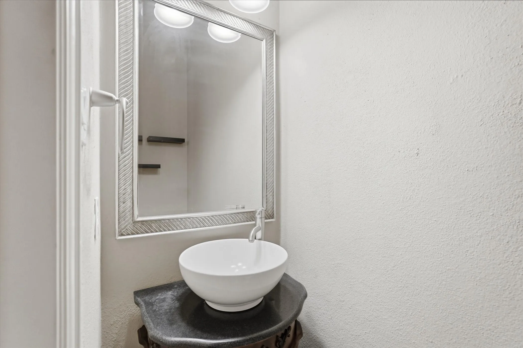 Bathroom with vanity and a textured wall