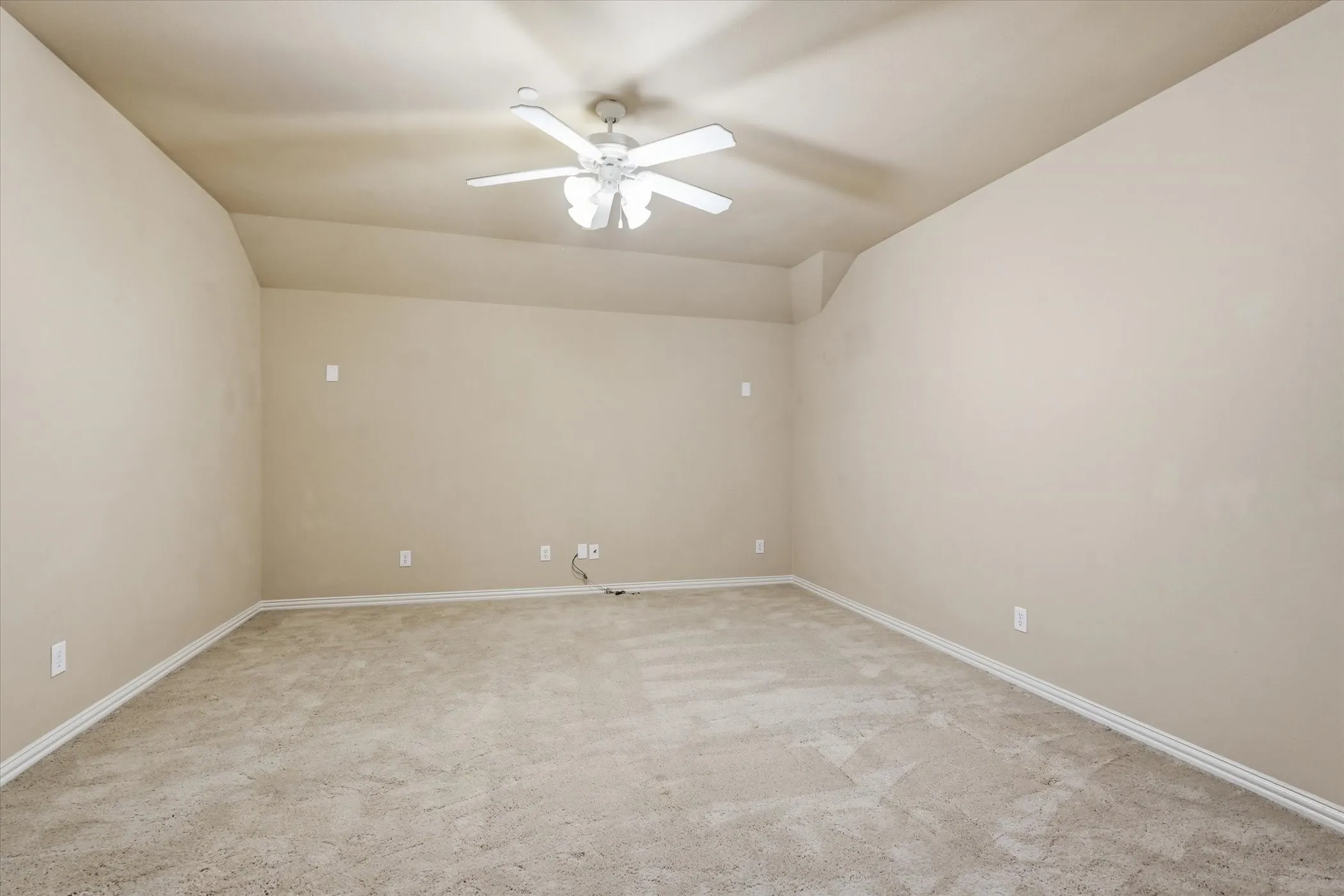 Spare room with light colored carpet, a ceiling fan, and lofted ceiling