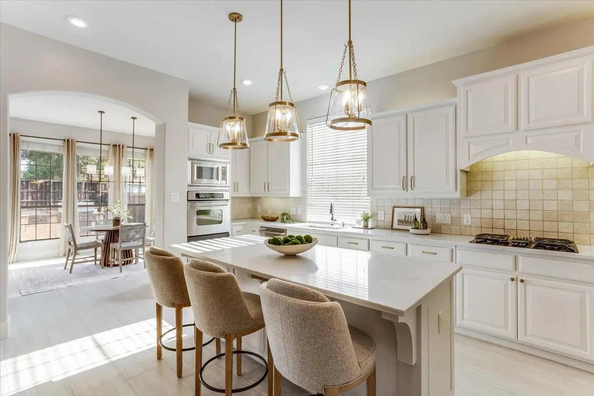 Kitchen featuring white cabinetry, stainless steel appliances, a center island with countertop seating, a tiled backsplash, and recessed and pendant lighting