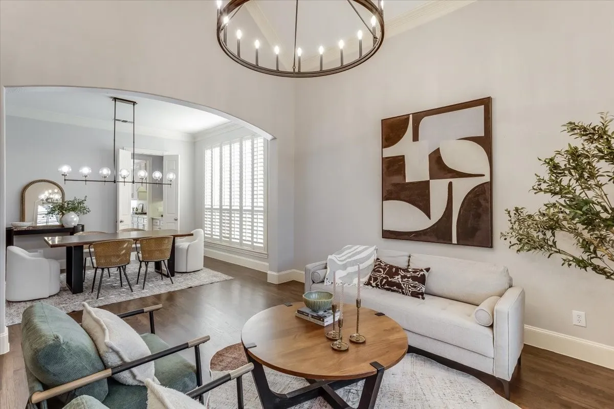 Arched entryway opening, wood-finish flooring, custom window shutters, contemporary chandelier, and recessed lighting