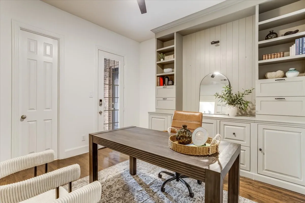 Built-in cabinetry with shelving and drawers, hardwood flooring, and a glass-paneled exterior door