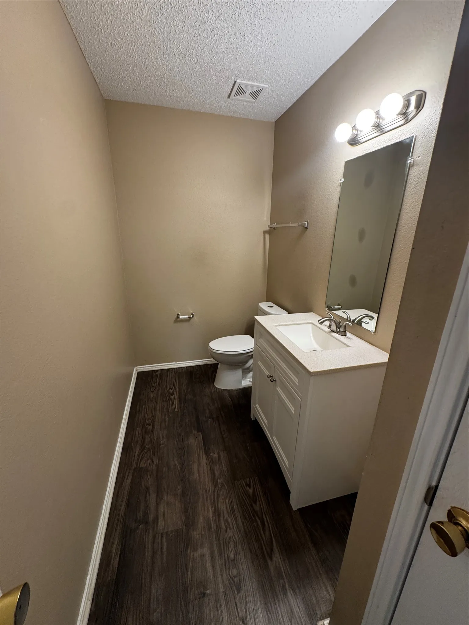 Vanity with storage cabinetry, integrated sink, and wall-mounted mirror