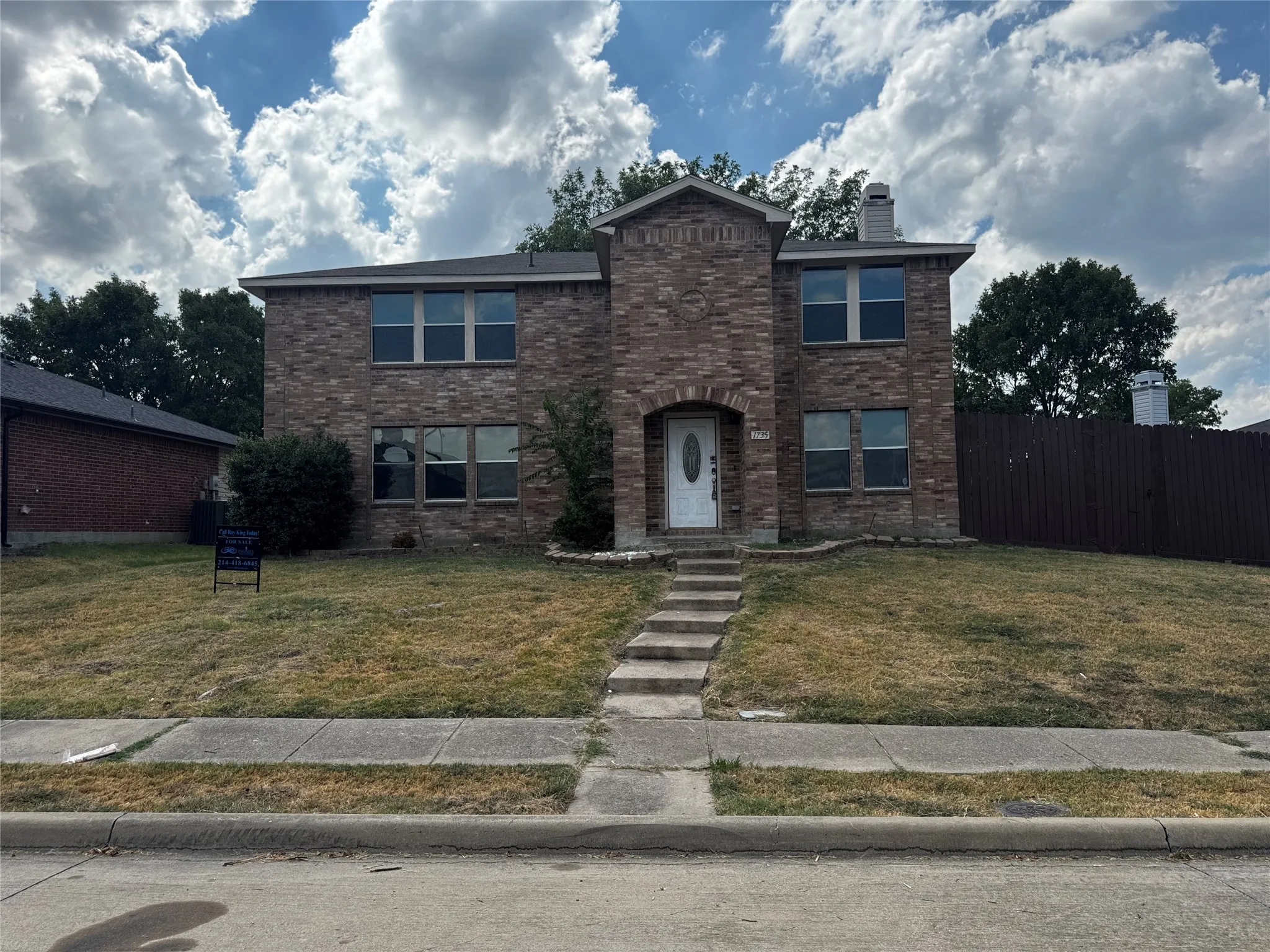 Two-story brick exterior with an arched entry and a white front door