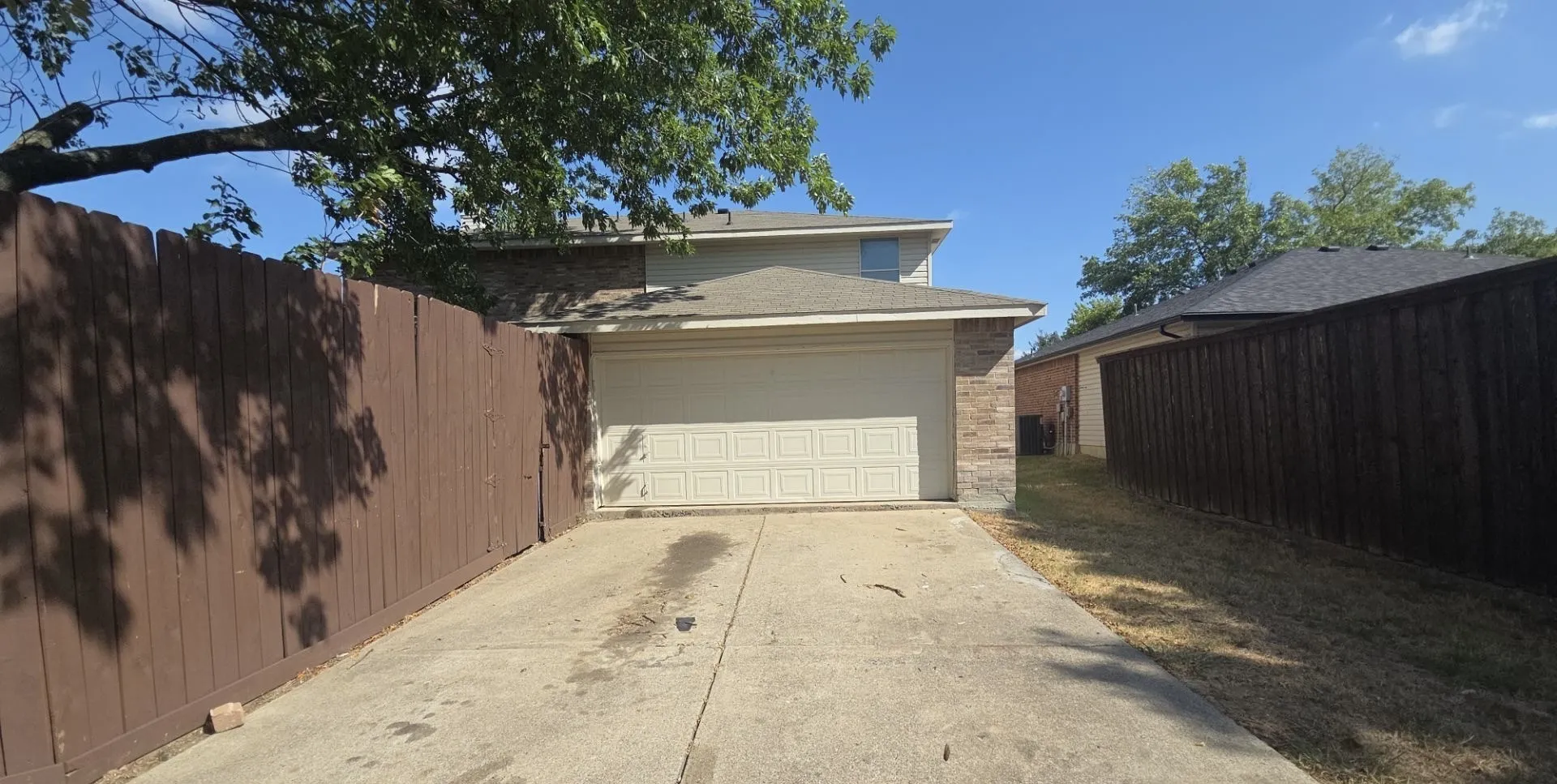 Two-story residence featuring a two-car garage, brick and siding exterior, and a concrete driveway