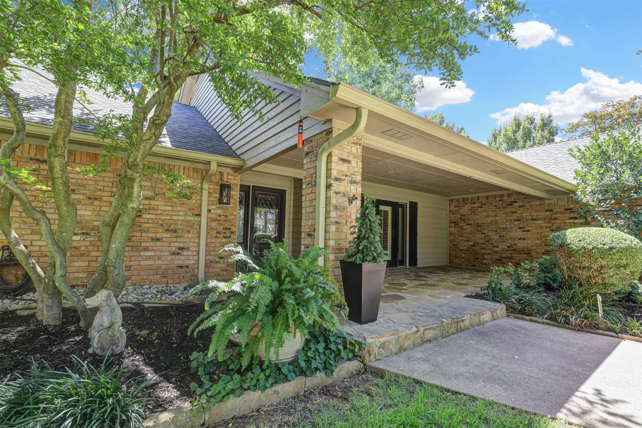Spacious covered porch with stone flooring and room for outdoor seating.