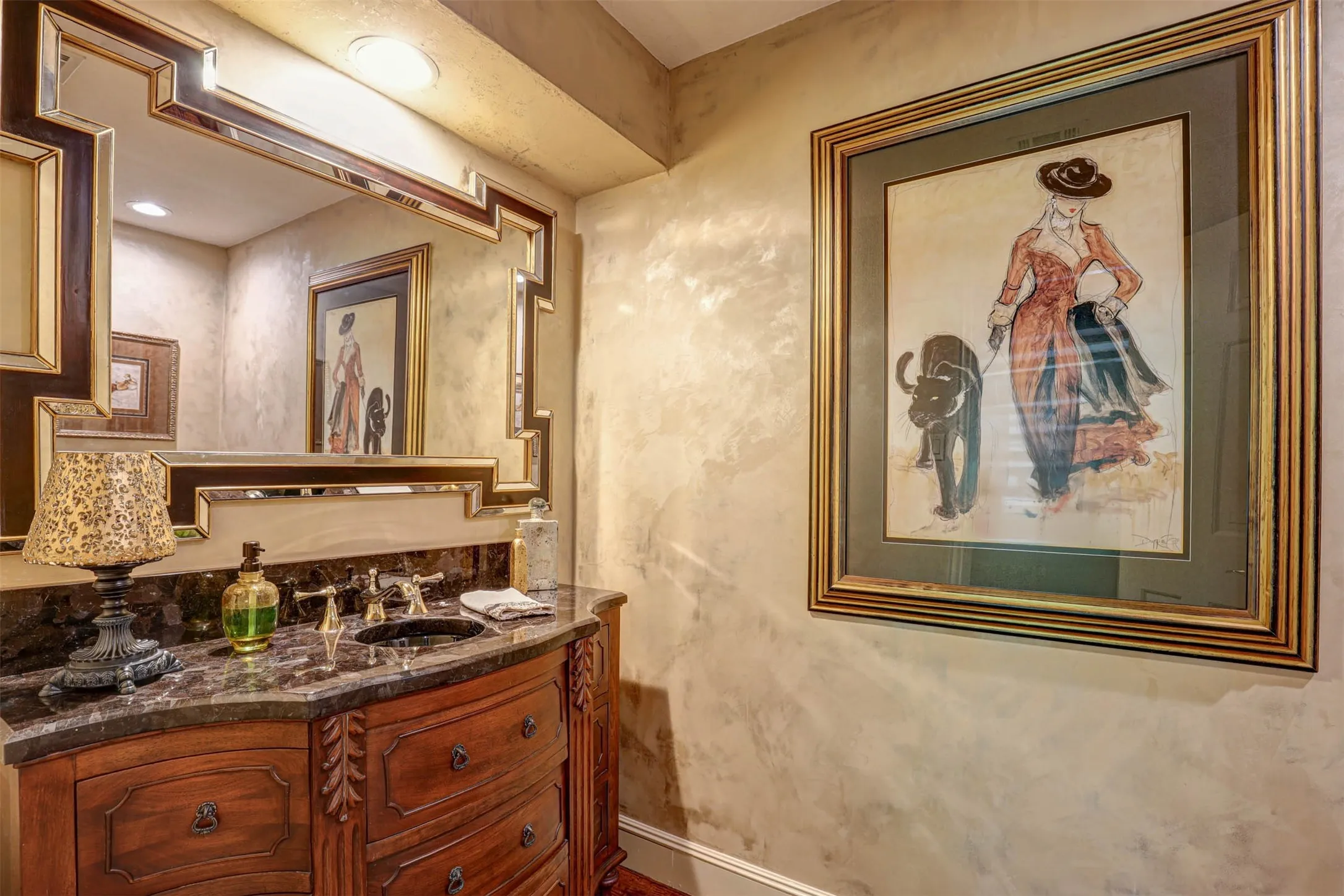 Elegant half bath with ornate vanity and marble style countertop.