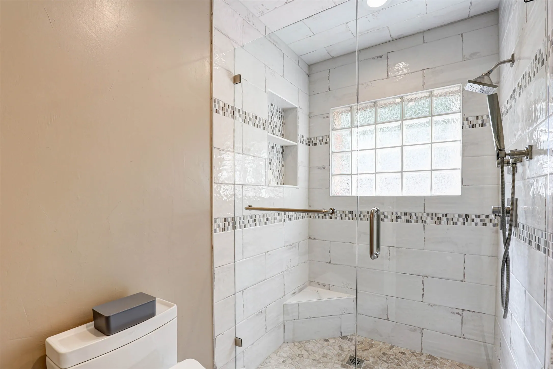 Oversized walk-in shower with upgraded tilework and a Japanese bidet system toilet.