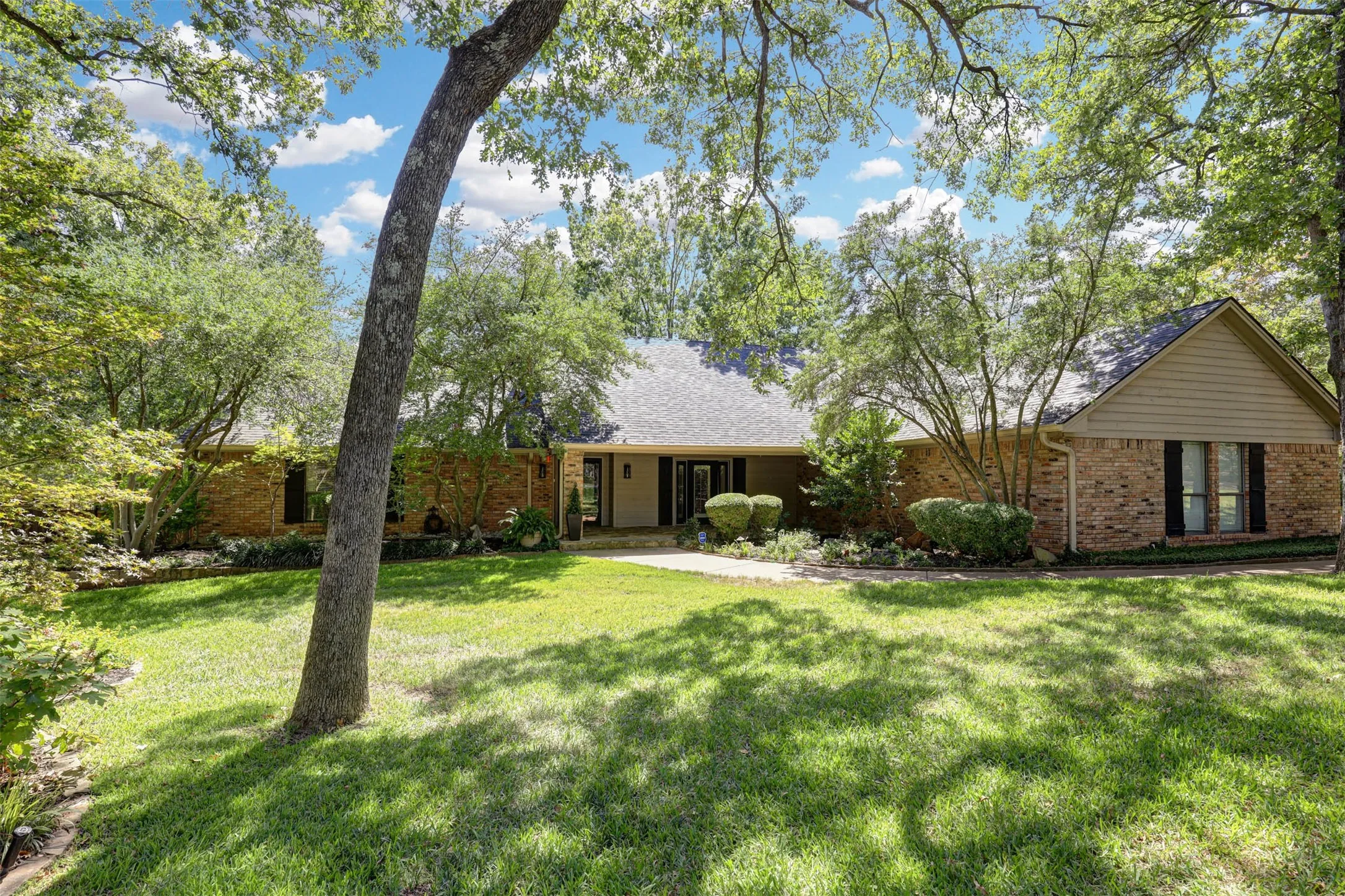 Beautiful front elevation set in a serene, wooded custom-home setting.