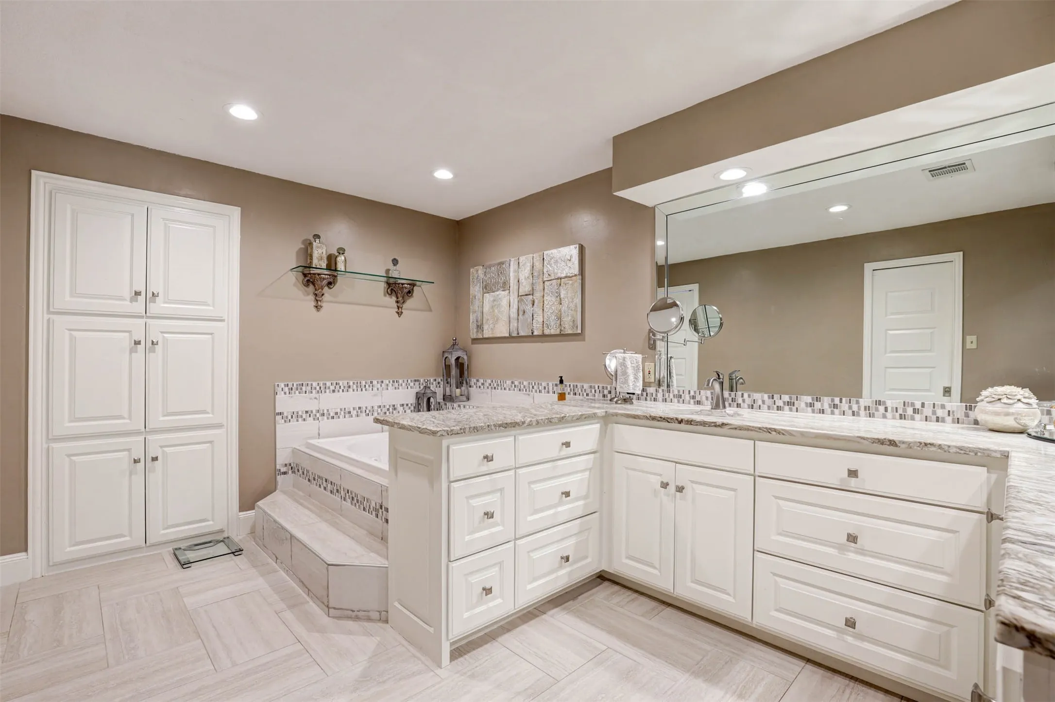 Primary bath featuring a Roman jetted tub with elegant tile surround.