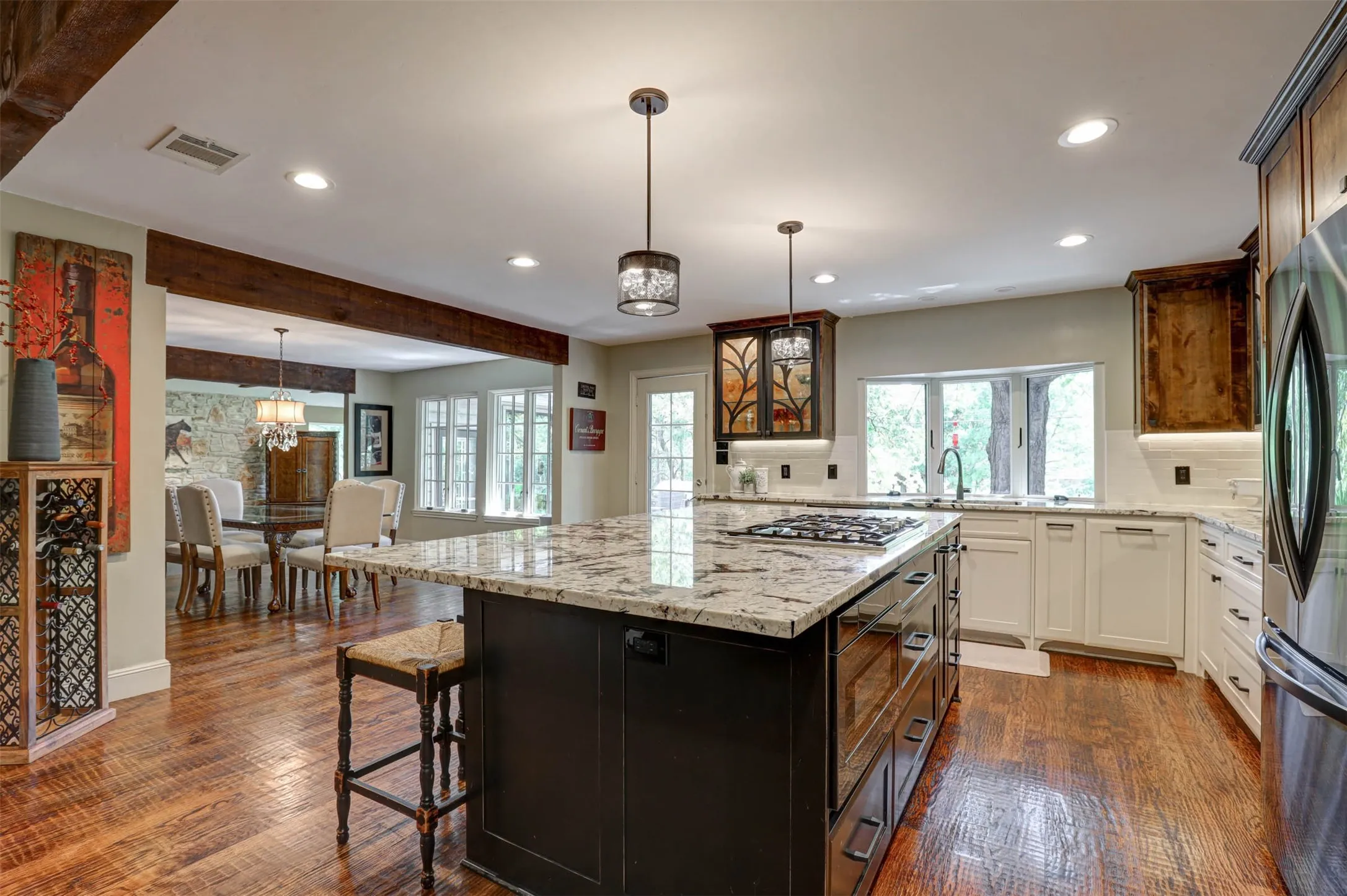 Open kitchen with full island, backyard facing windows, and seamless flow to the dining area.