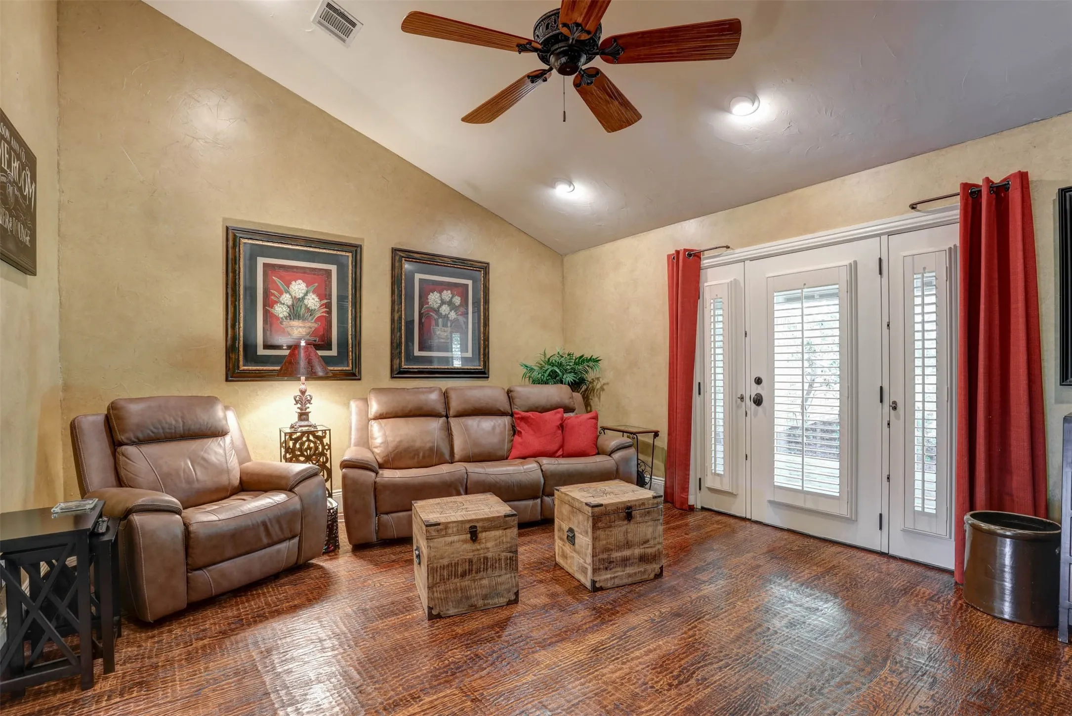Flexible den with windowed doors, angled ceiling, and plantation shutters.