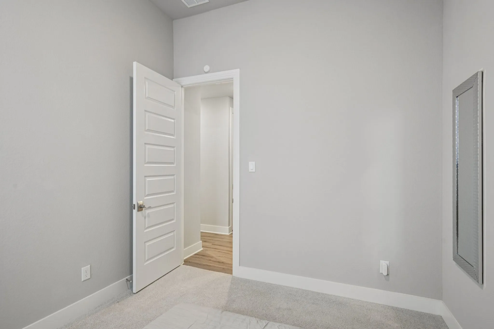 Recessed lighting, wood-finish flooring, and light wall tones