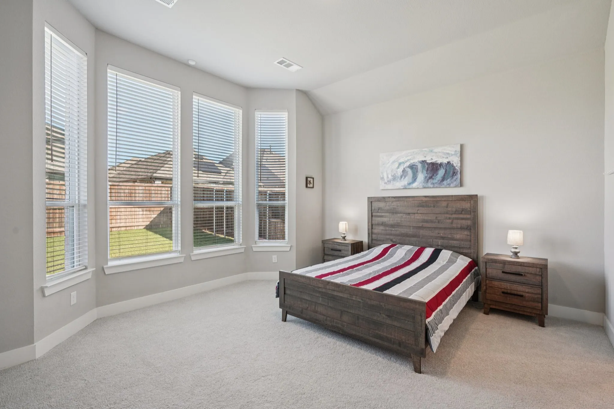 Recessed lighting, light gray wall color, light gray carpeting, and multiple windows with blinds
