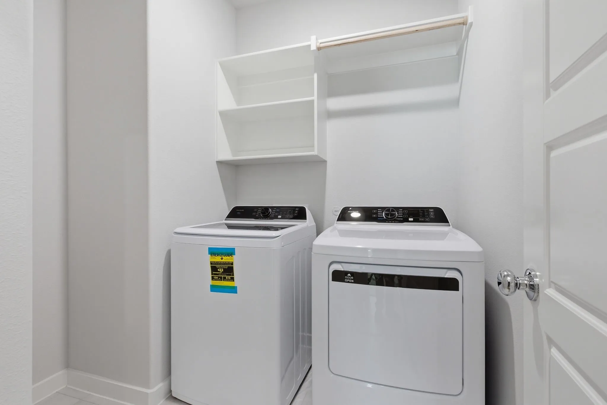 Laundry area featuring white appliances, built-in shelving, and a hanging rod