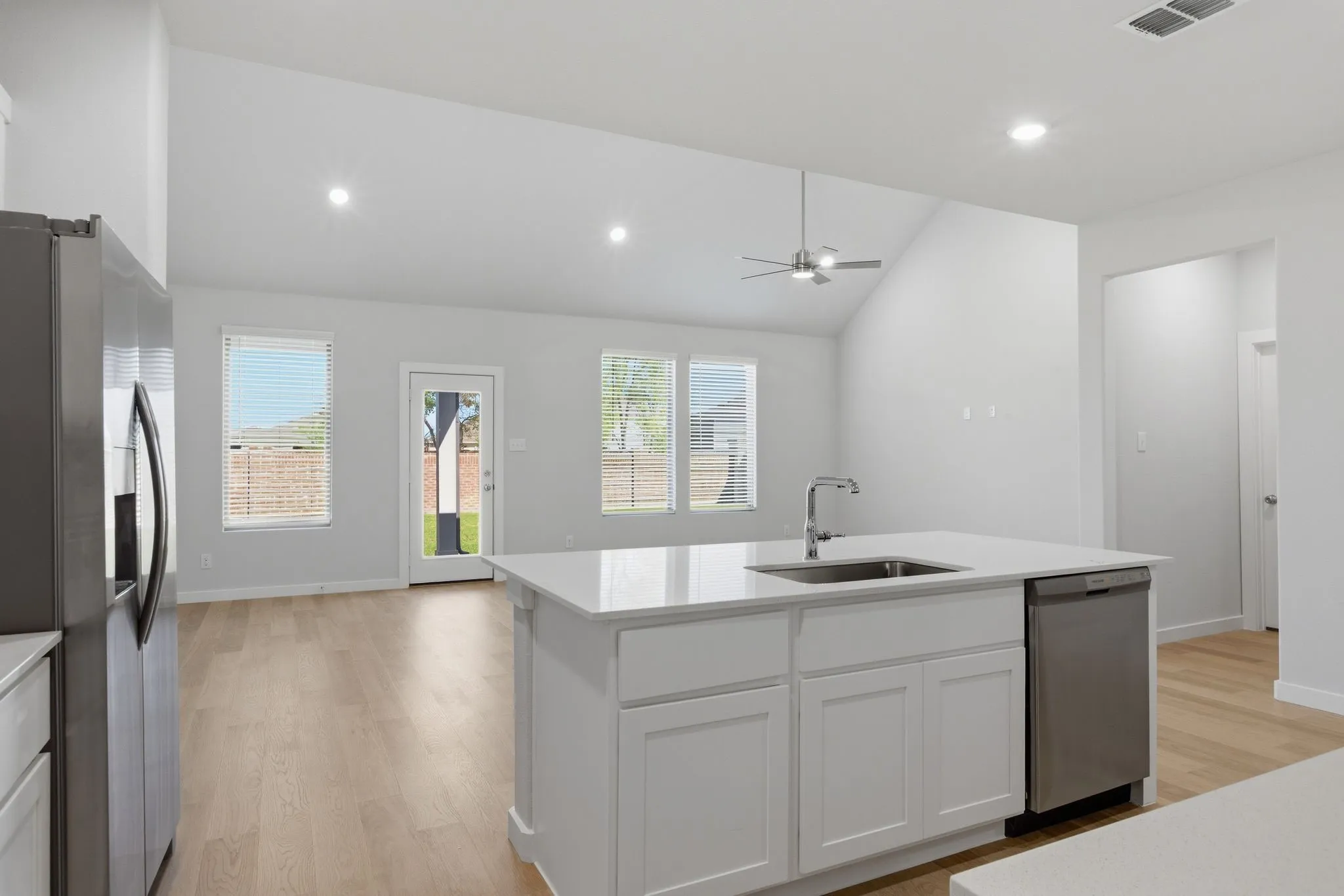 Kitchen island with white cabinetry, stainless steel sink, and dishwasher