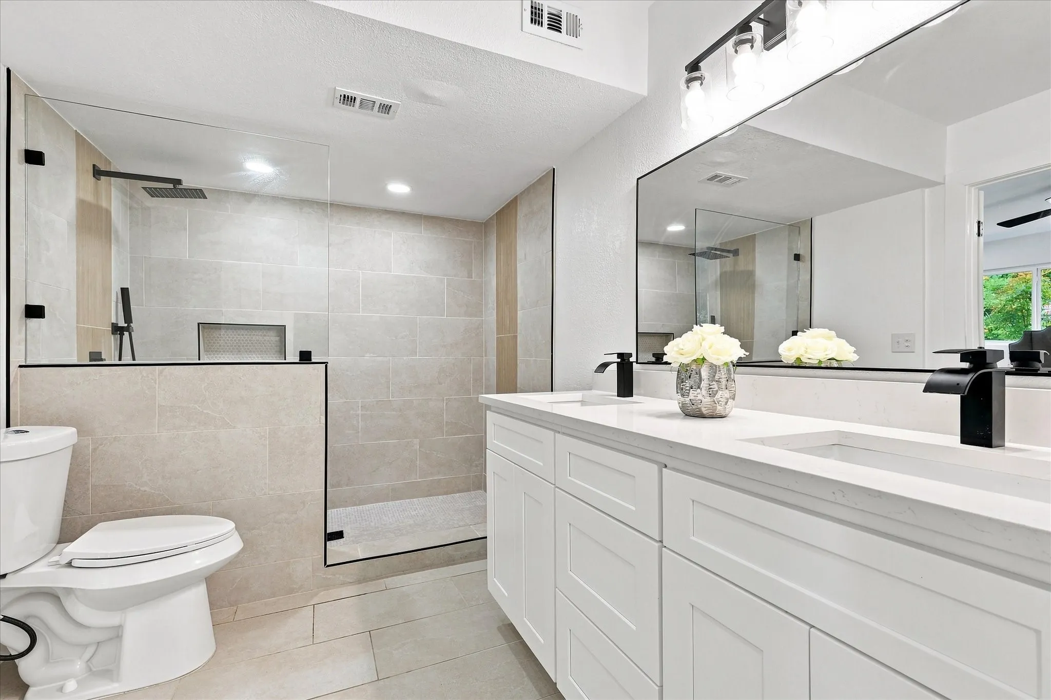 Dual vanity with integrated sinks, quartz countertop, and black fixtures