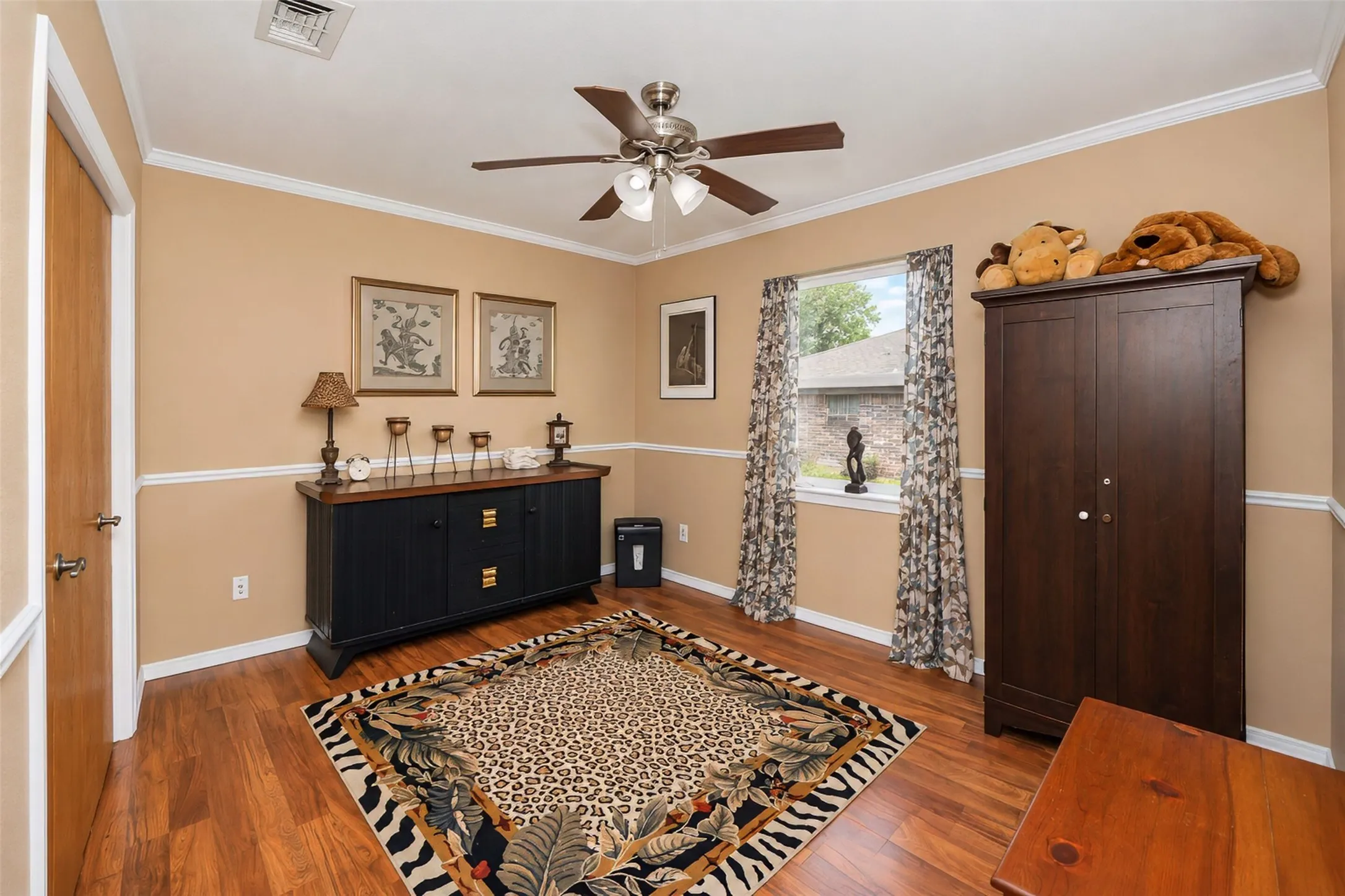 Wood-finish flooring with crown molding and chair rail detailing