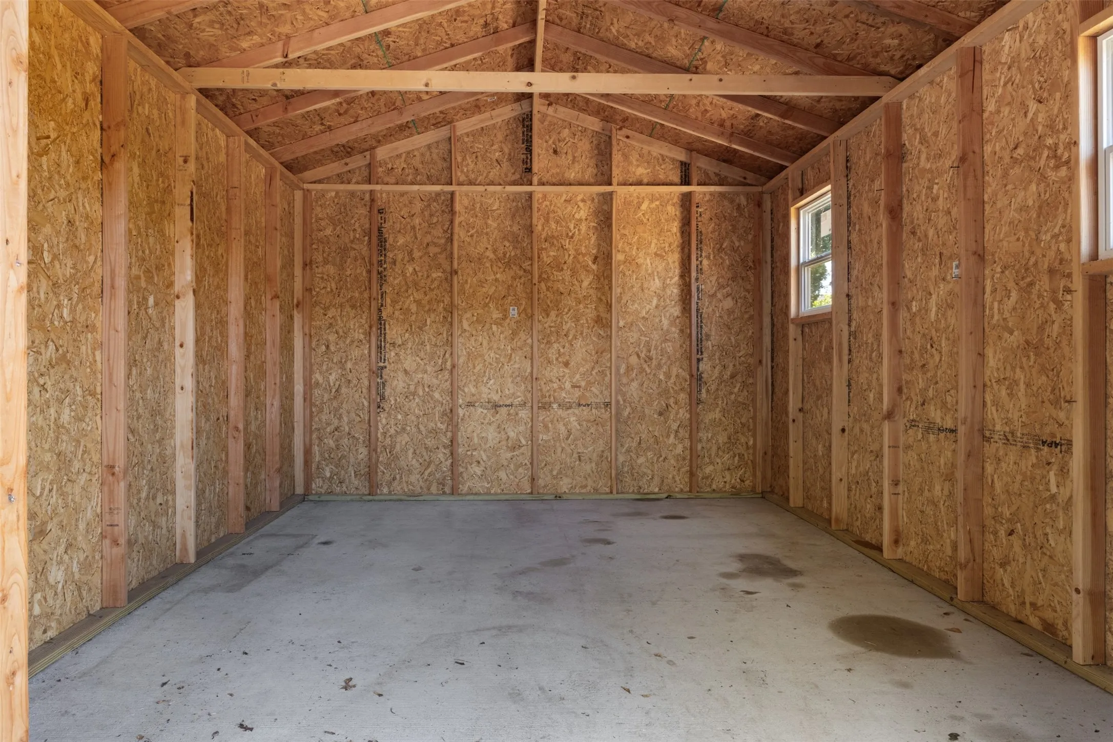 Unfinished interior with exposed wood framing and oriented strand board walls