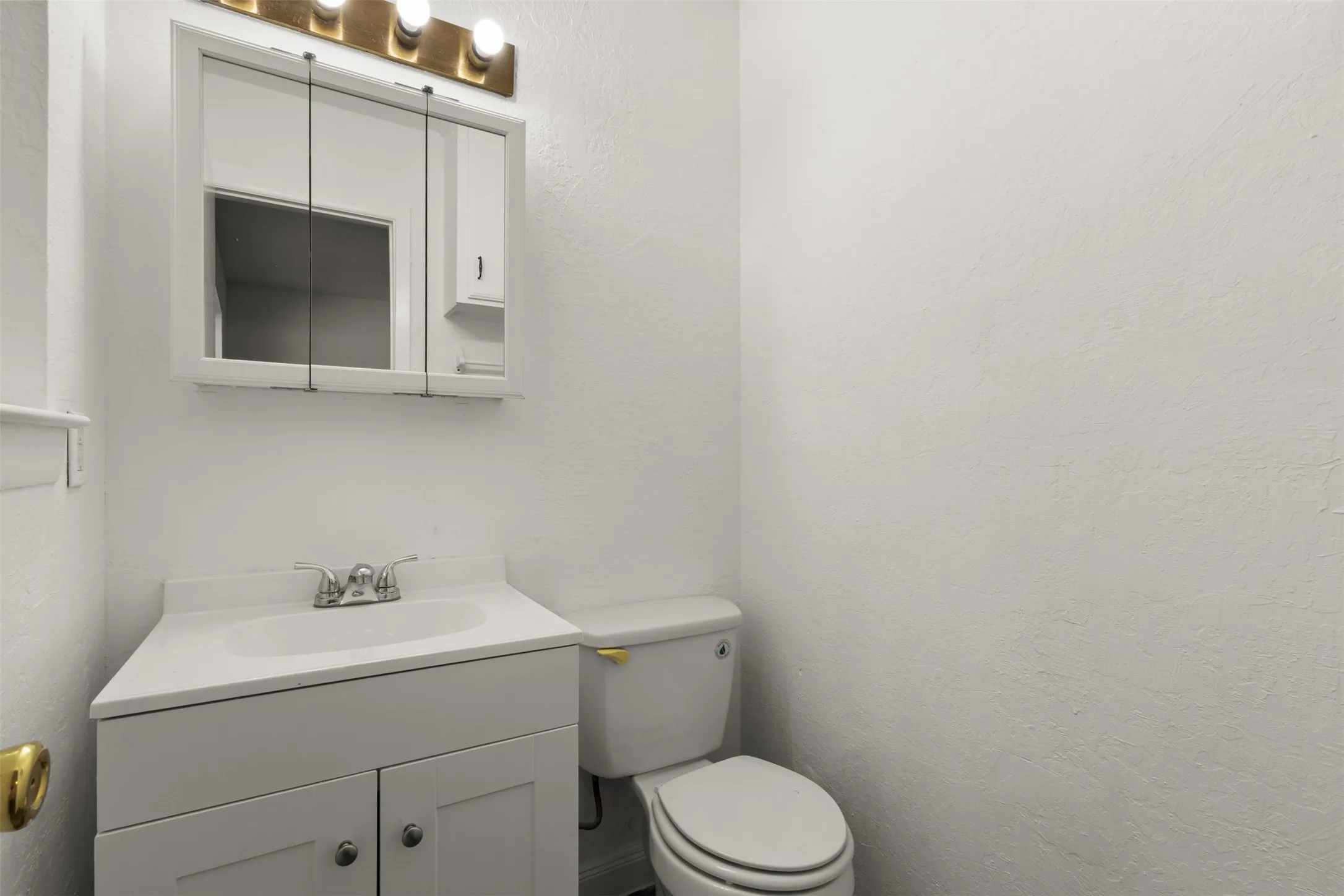 White vanity with double-door cabinetry, integrated sink, and chrome-finish faucet