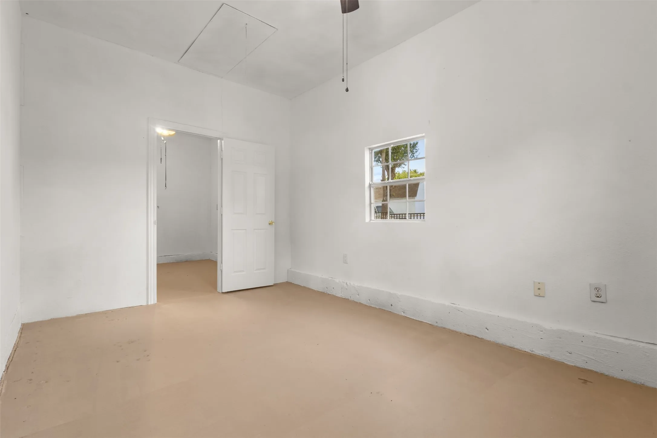 Neutral wall paint, ceiling fan, natural light, and an access panel